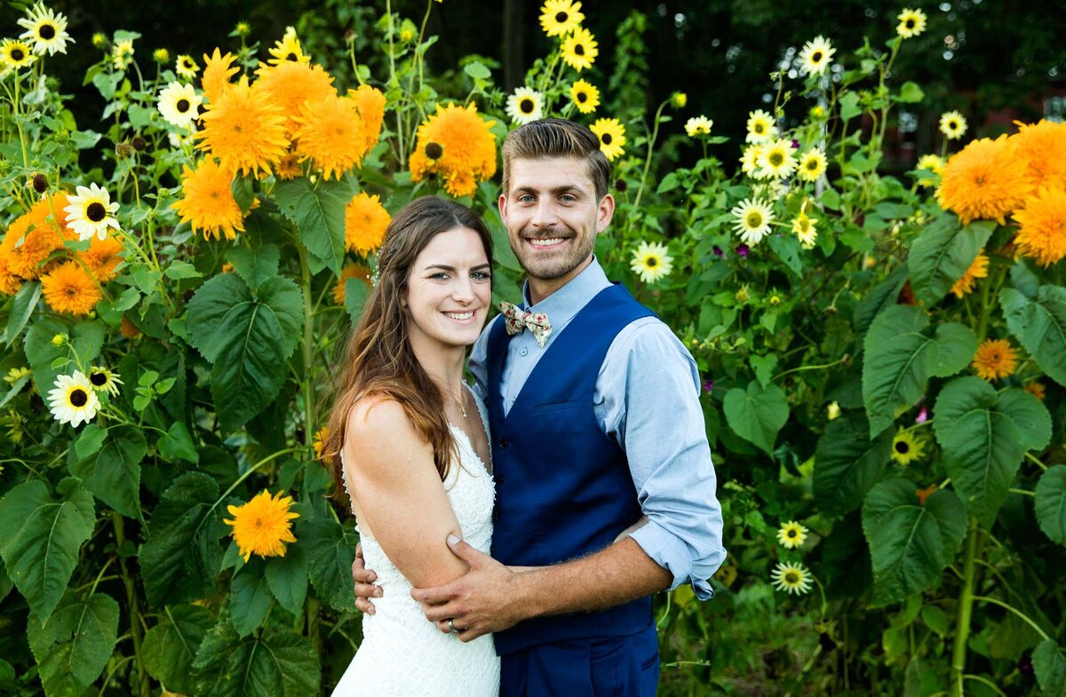 Bride and groom standing in front of a field of sunflowers at a private estate wedding in Pennsylvania 