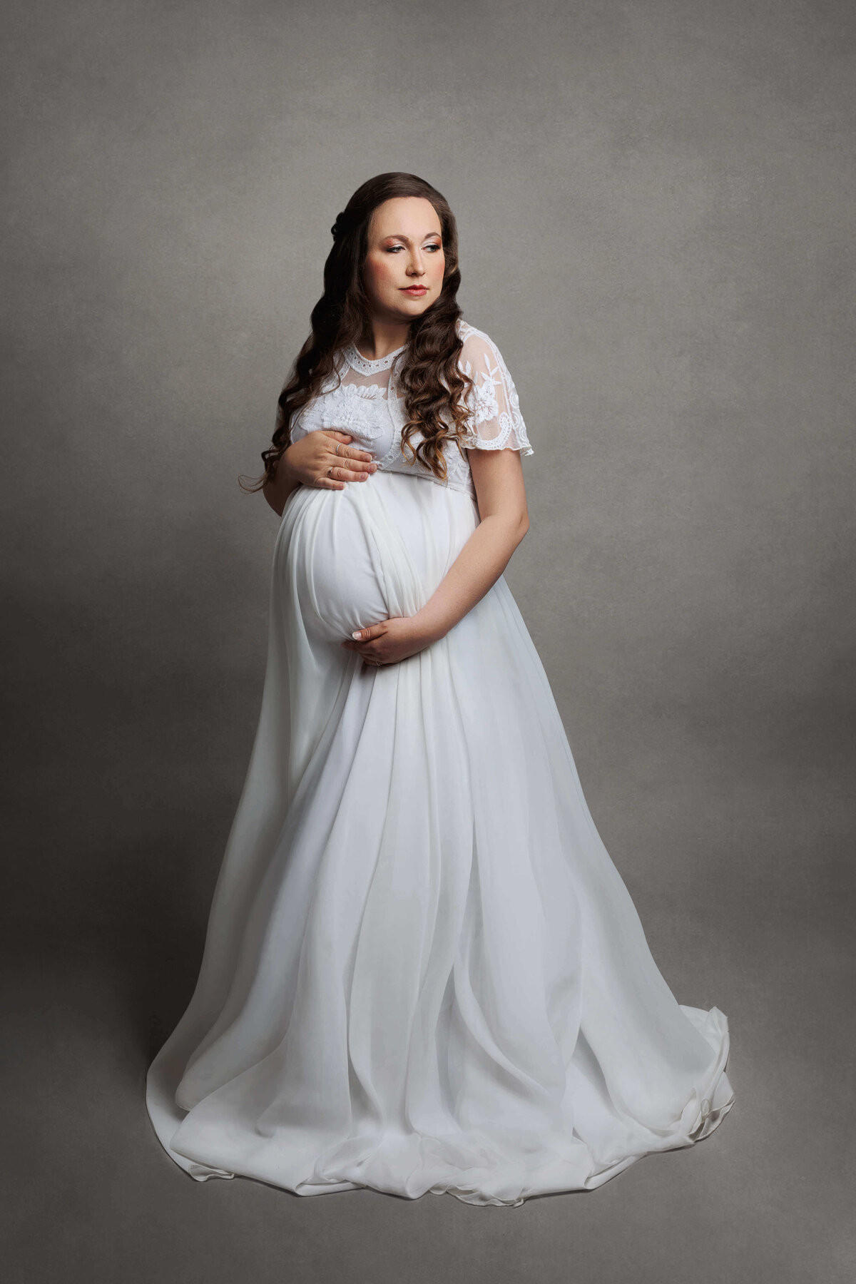 pregnant mother wearing a white maternity gown at her pregnancy session in northern va