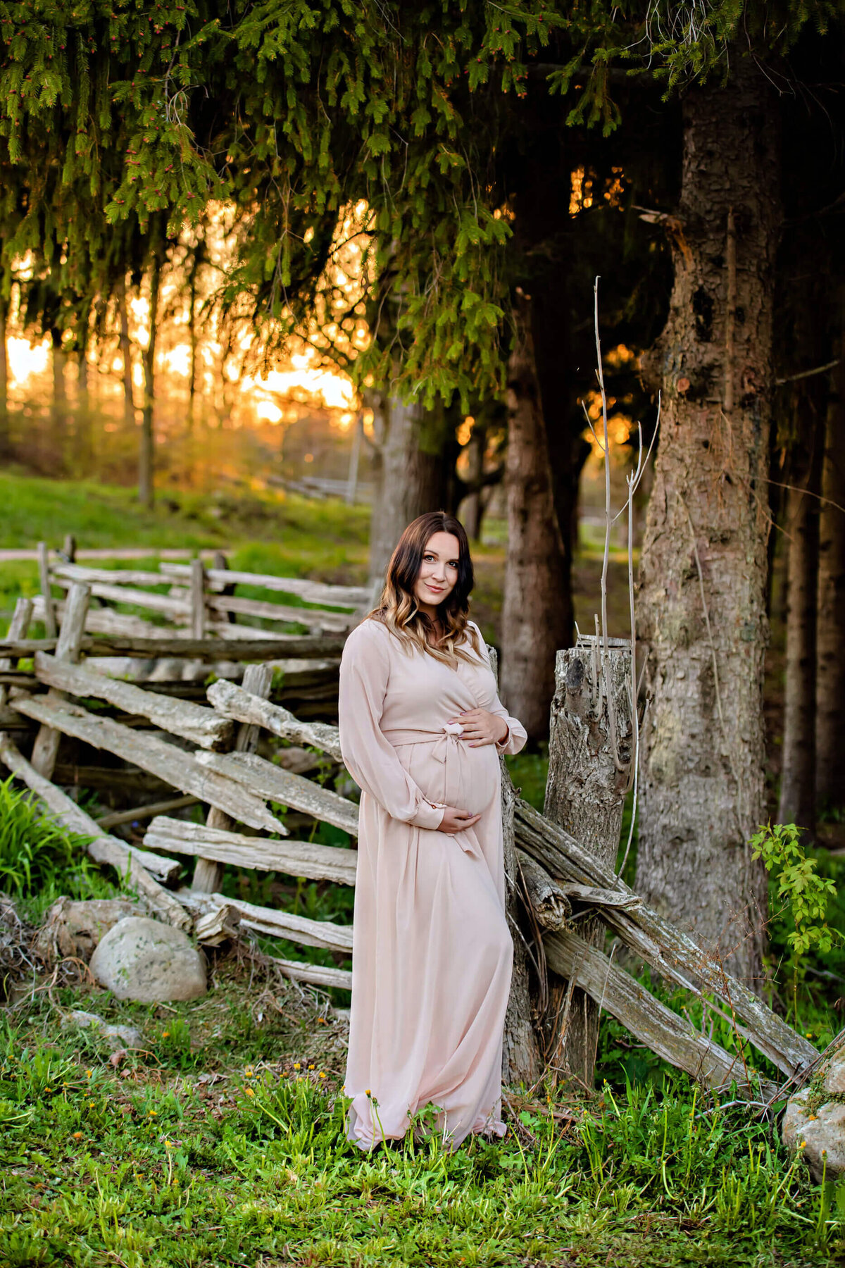 pregnant woman wearing a pink dress holding her belly