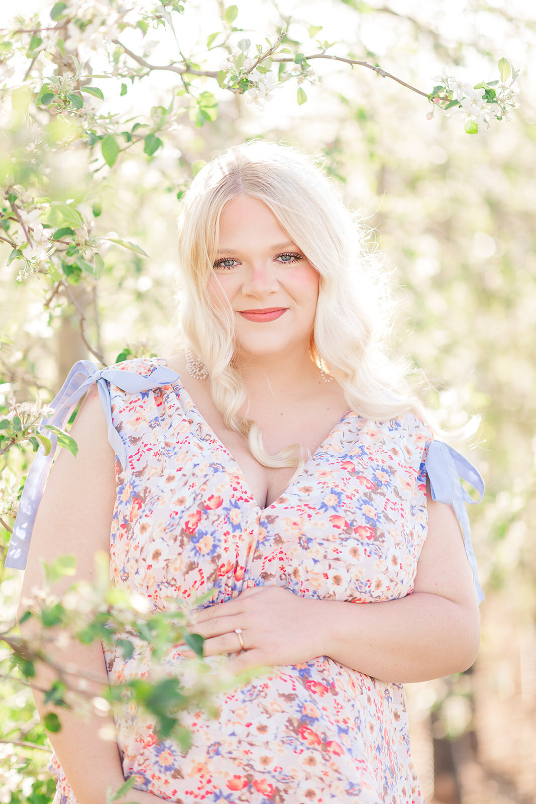 Soft, natural light over blooming apple trees for maternity photos