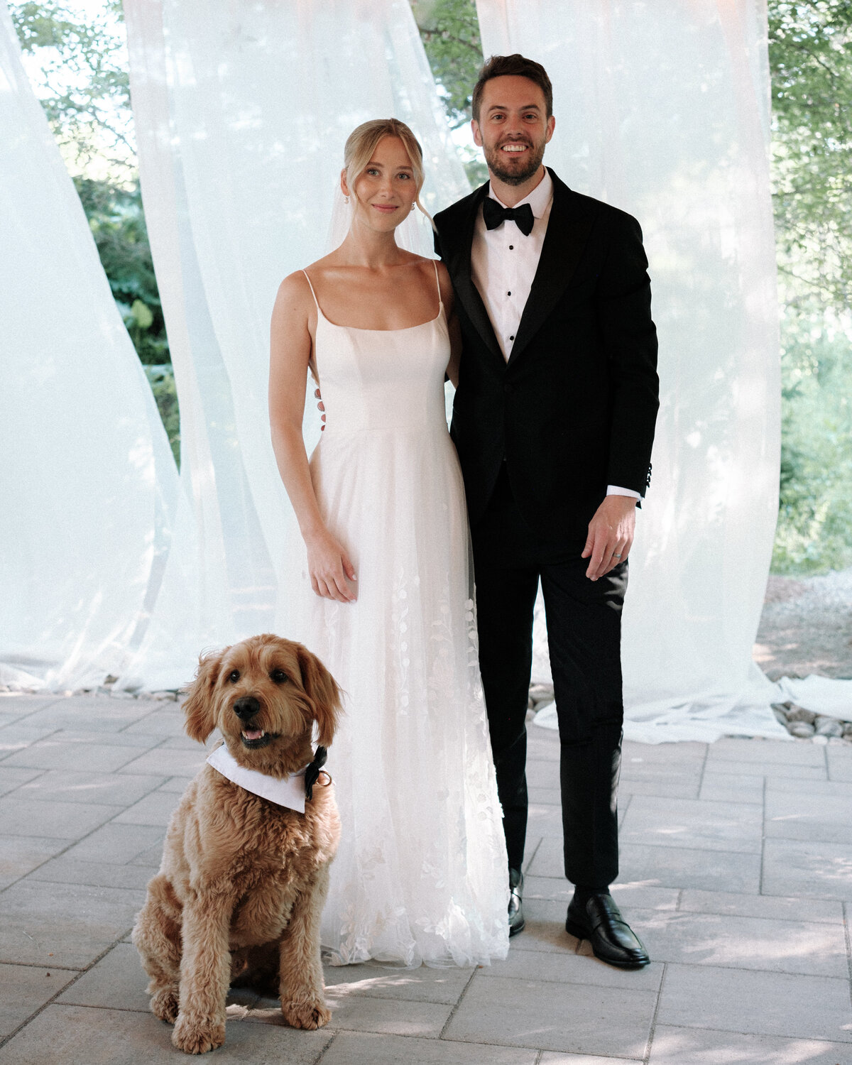 Bride and groom with dog in wedding attire