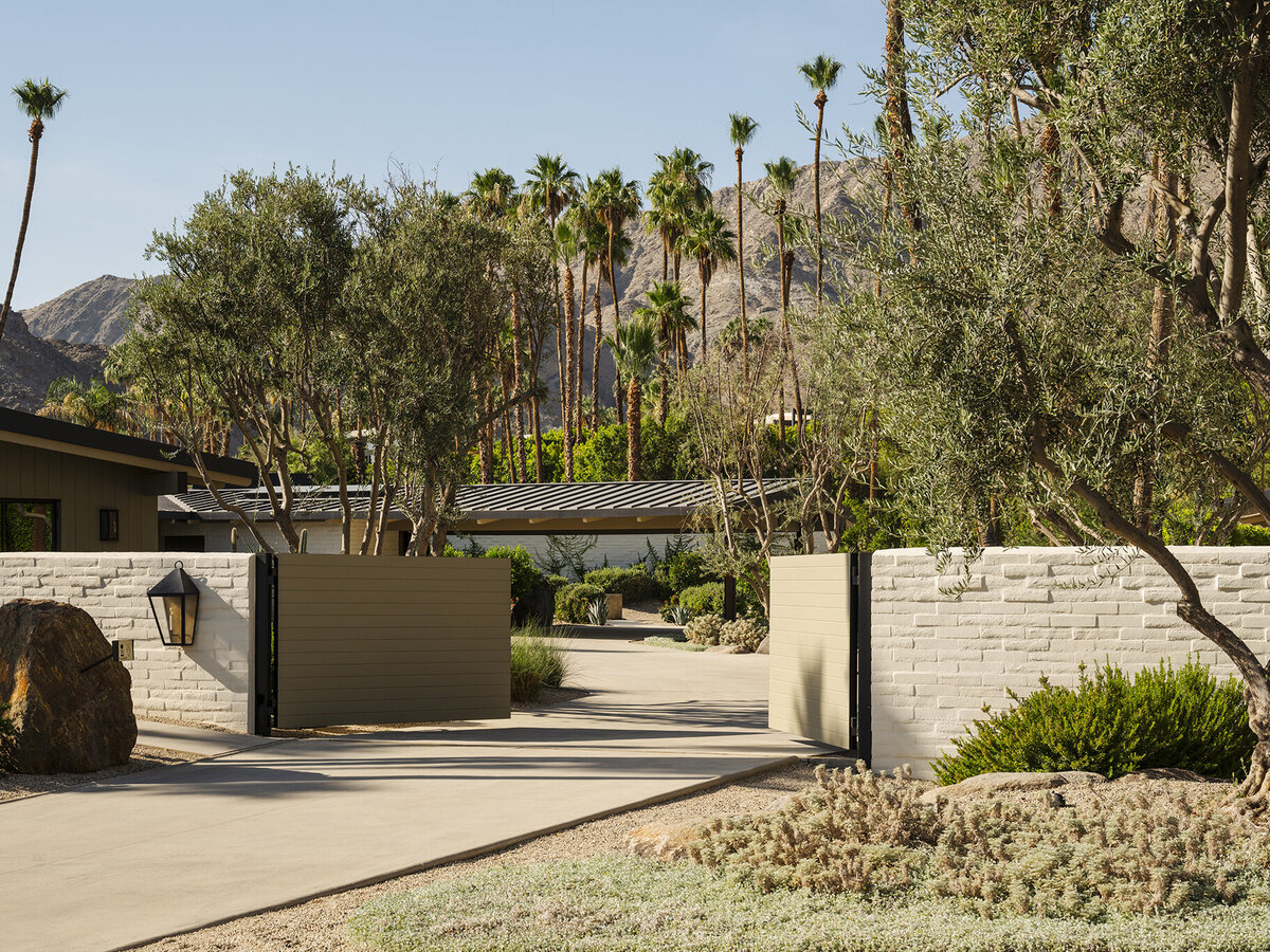 Street view of custom residential home with mountain and palm tree background views