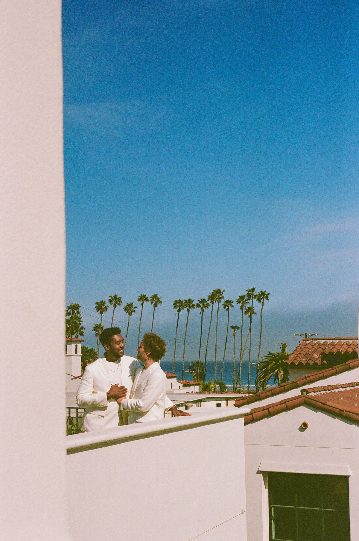 A couple standing together on a balcony.