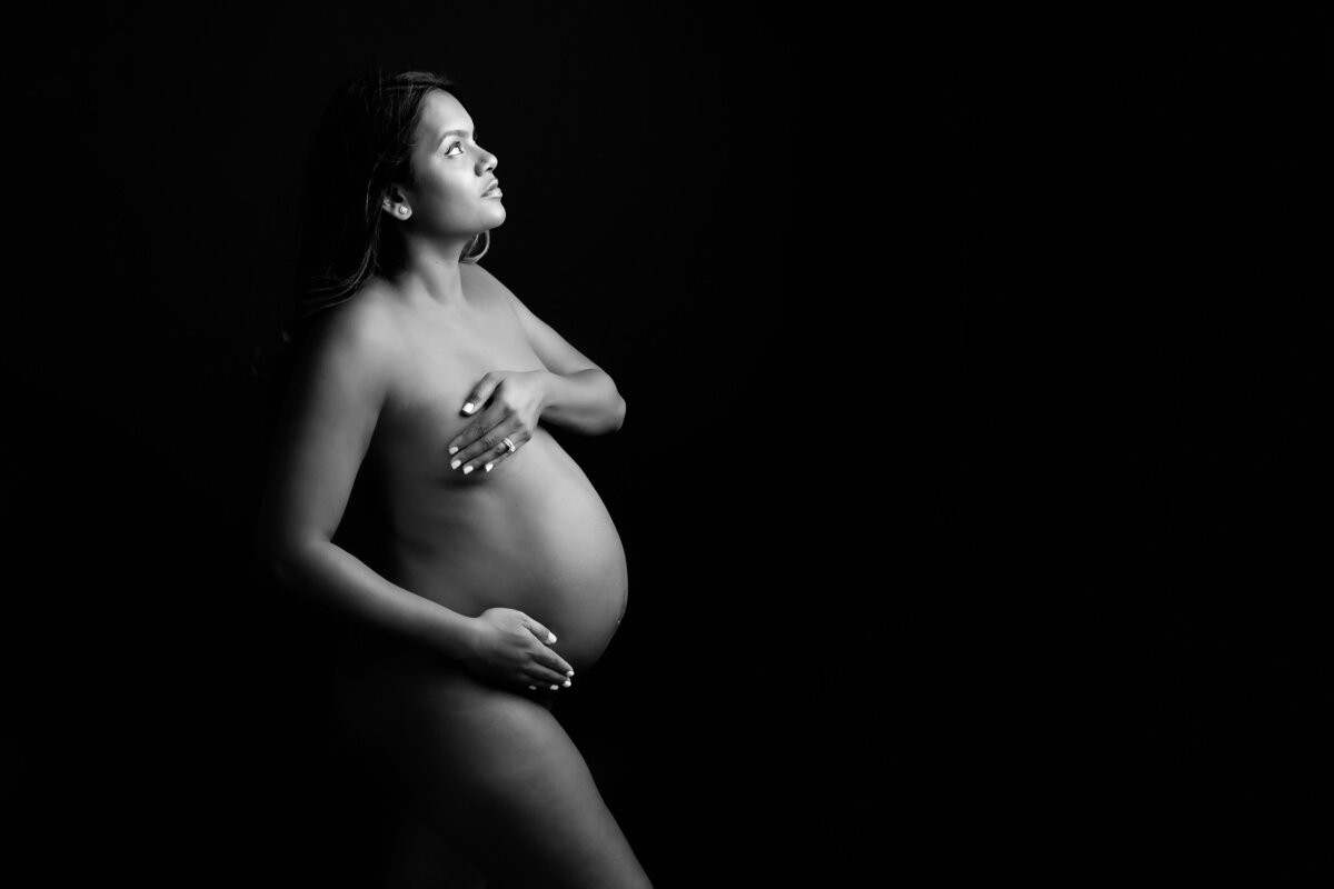 black and white photo of a pregnant woman at her maternity boudoir photography session