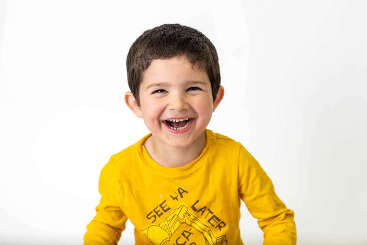 Little boy smiling in yellow shirt