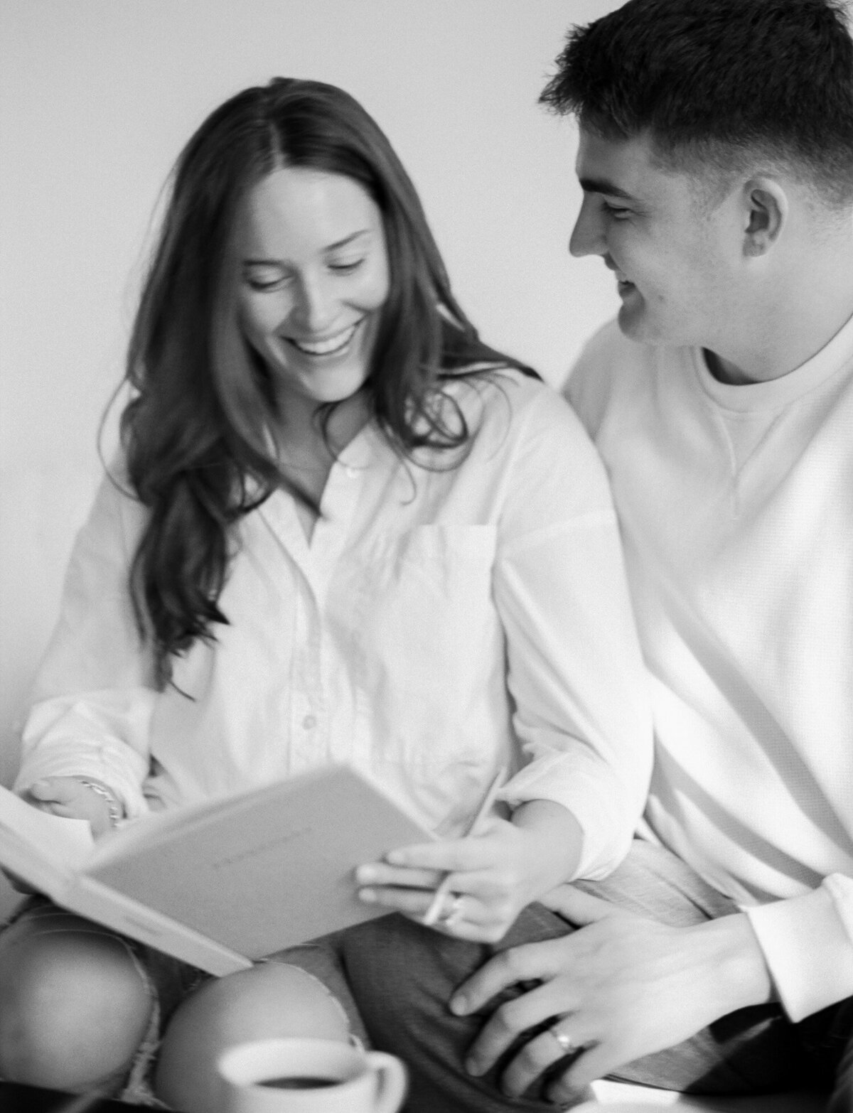 soft film branding photo of couple laughing, journaling, Season Journals brand photoshoot