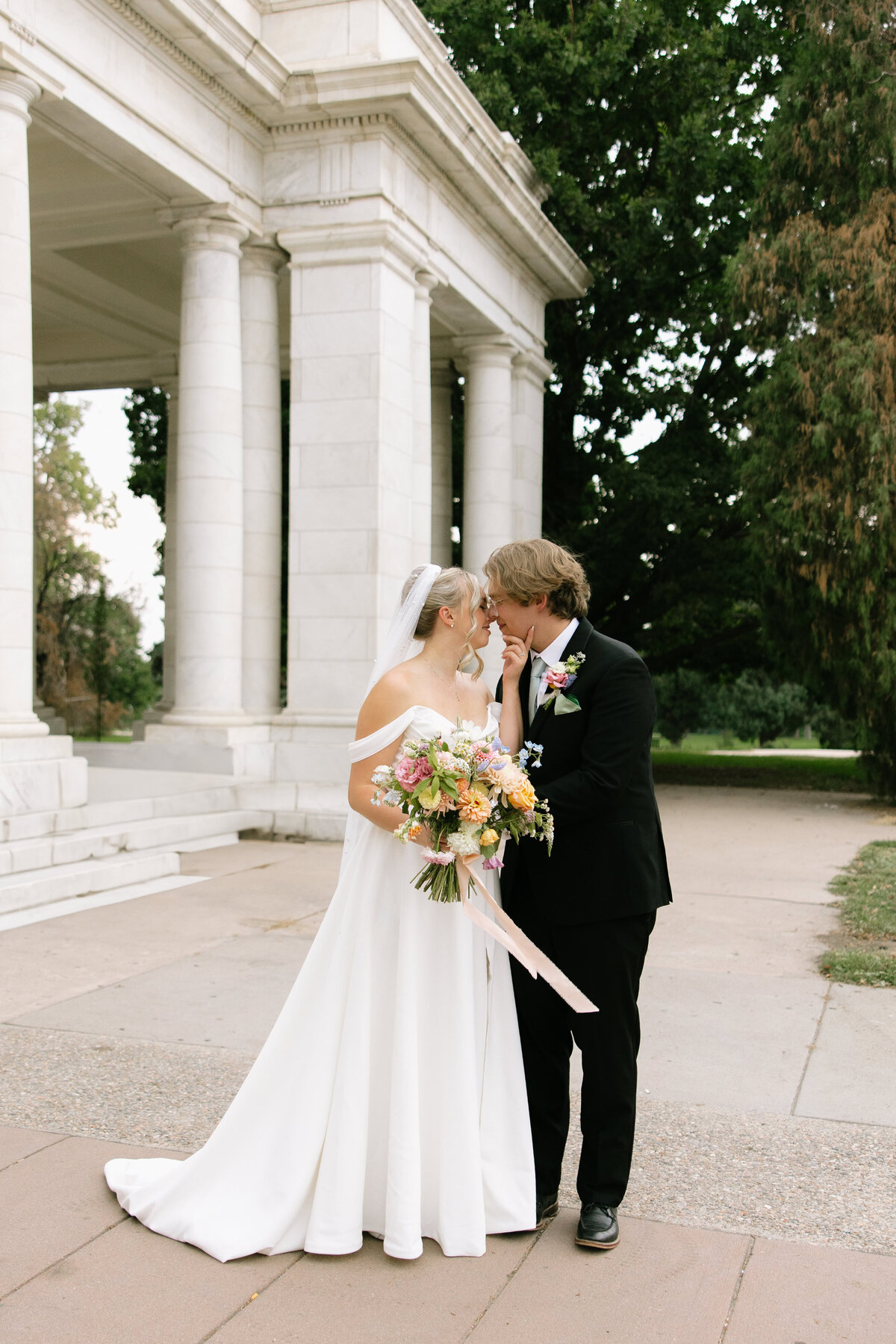 A bride and groom embrace at Cheesman Park in Denver, Colorado.
