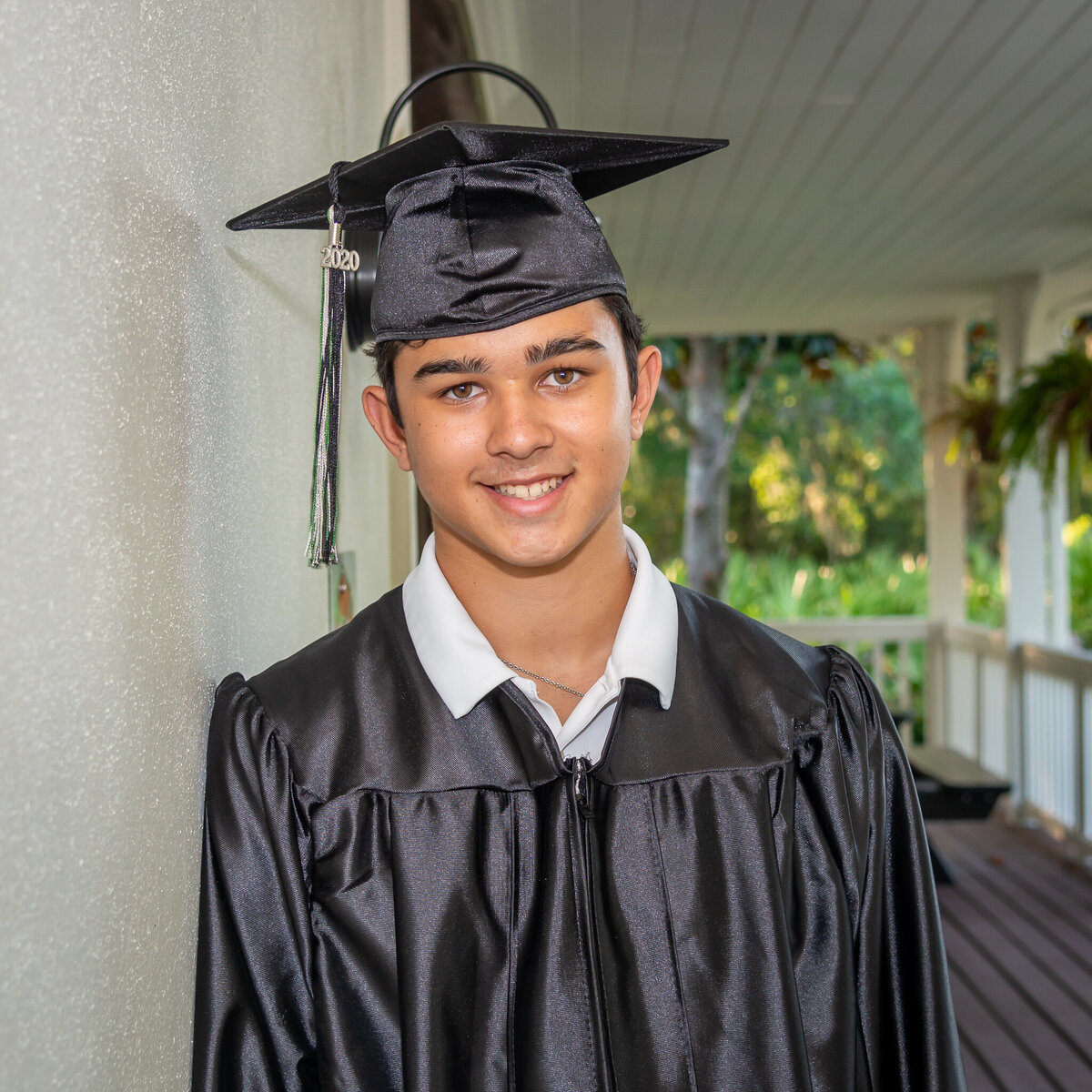 A senior poses for his cap and gown photos