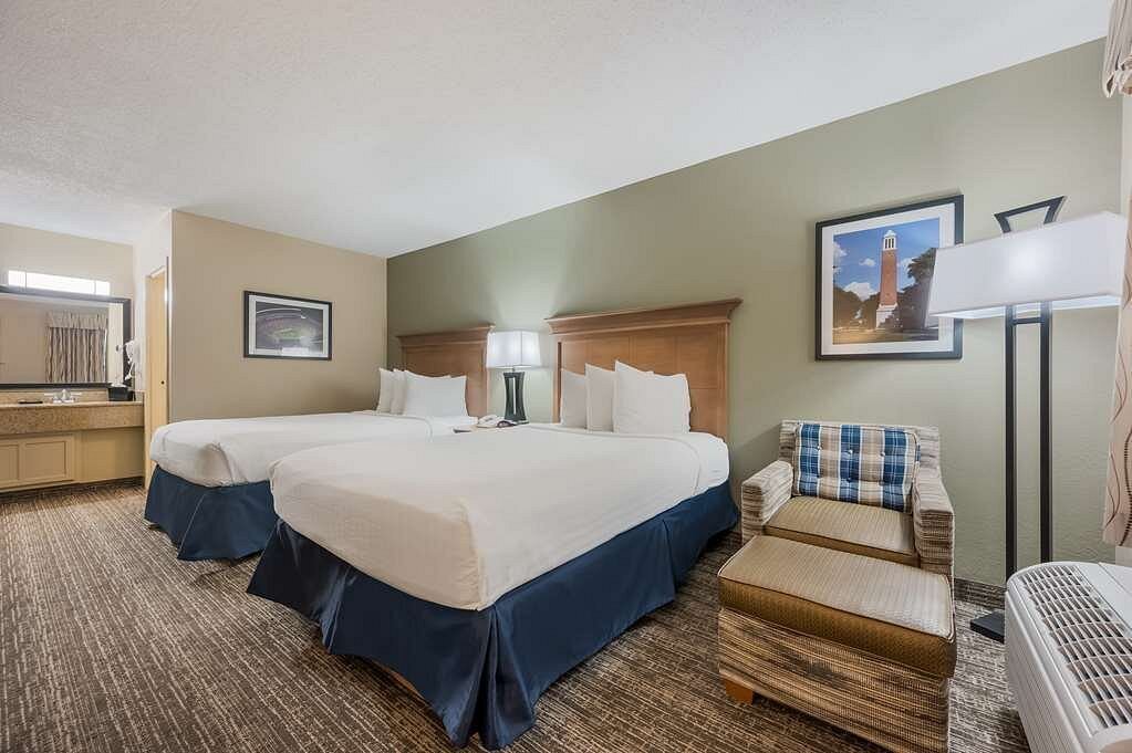 Hotel double queen guest room with lounge chair and plaid accent