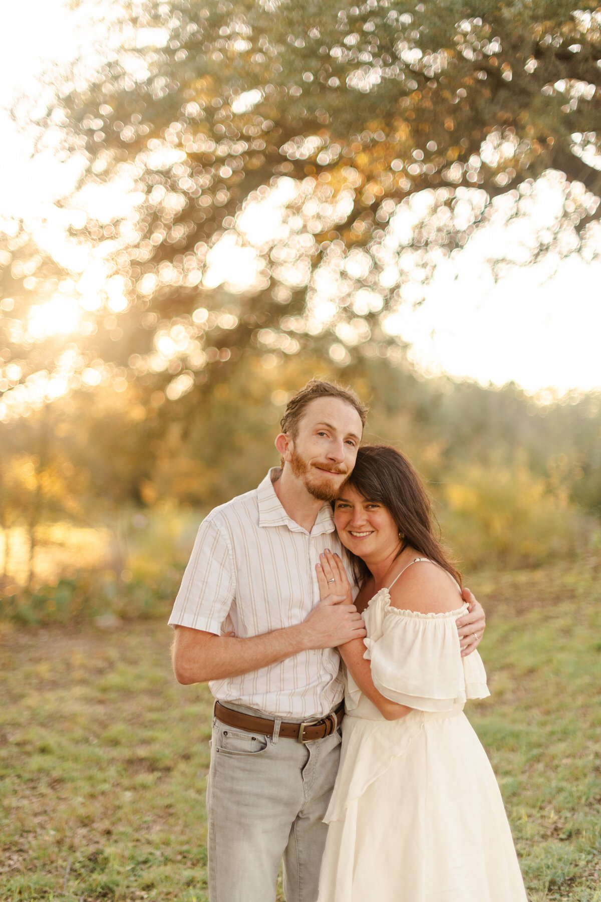 Stephanie & Dylan embrace under an oak tree during their honeymoon trip