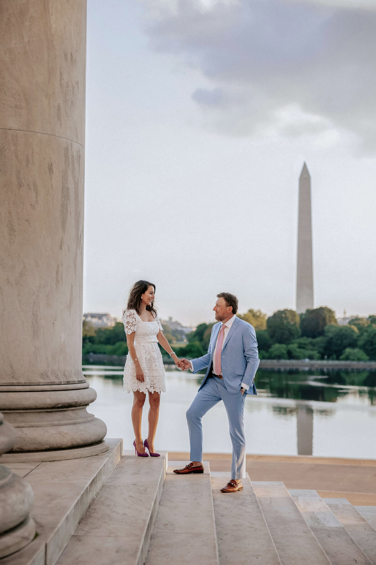 couple-holding-hands-in-front-of-washington-monument-overlooking-tidal-basin