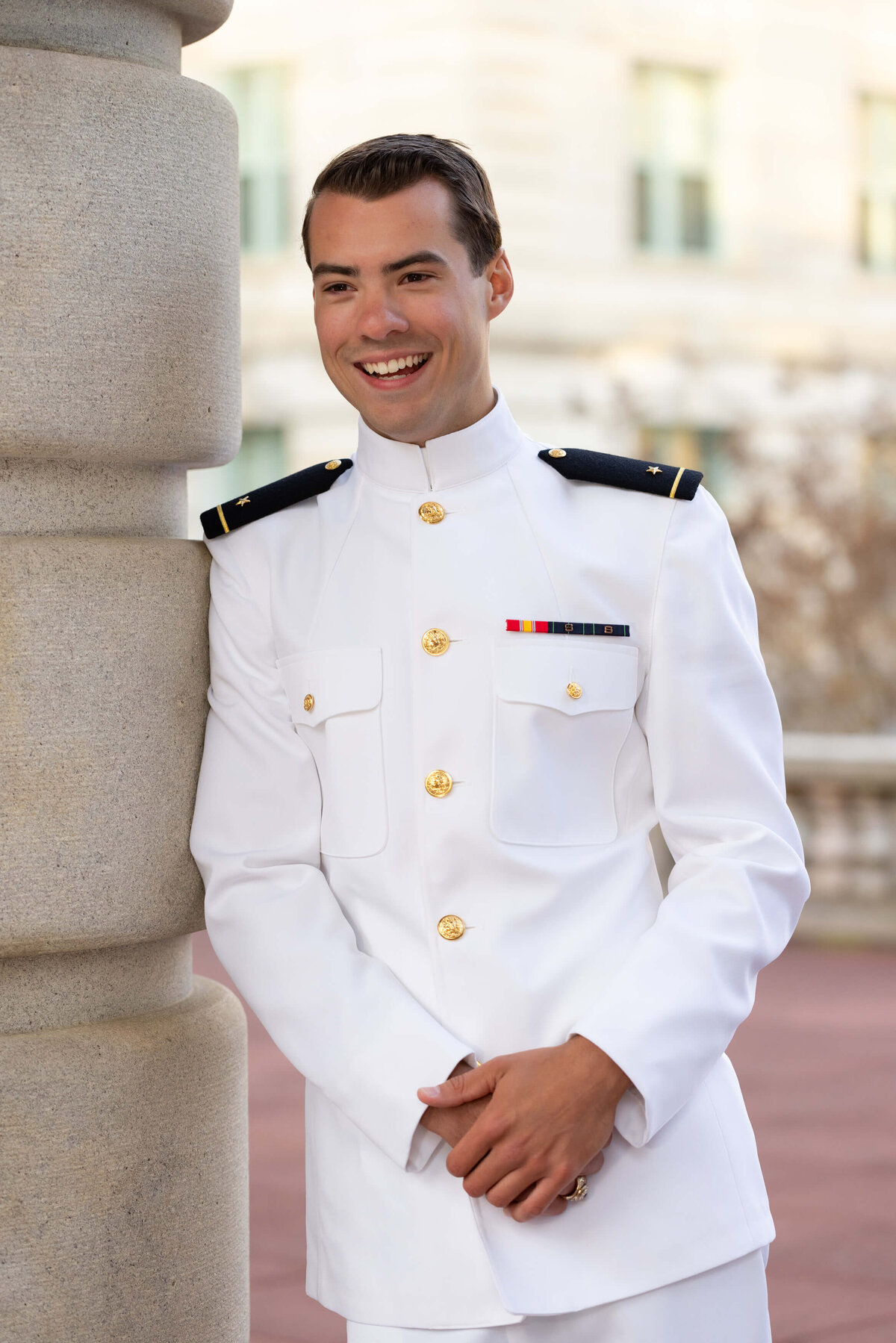 Naval Academy graduate laughing for senior photos in Annapolis, Maryland.