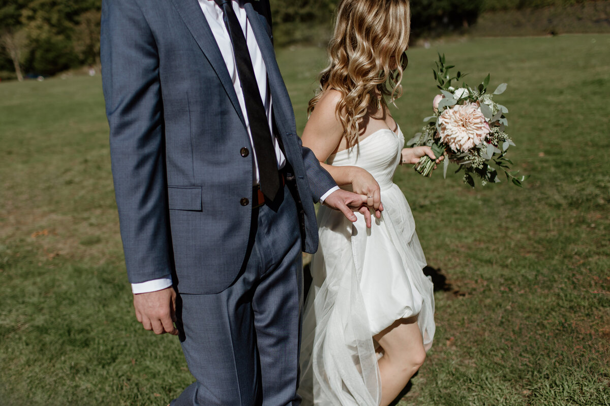 A quiet candid moment of a bride and groom sweetly interlocking their fingers. Captured by Fort Worth wedding photographer, Megan Christine Studio