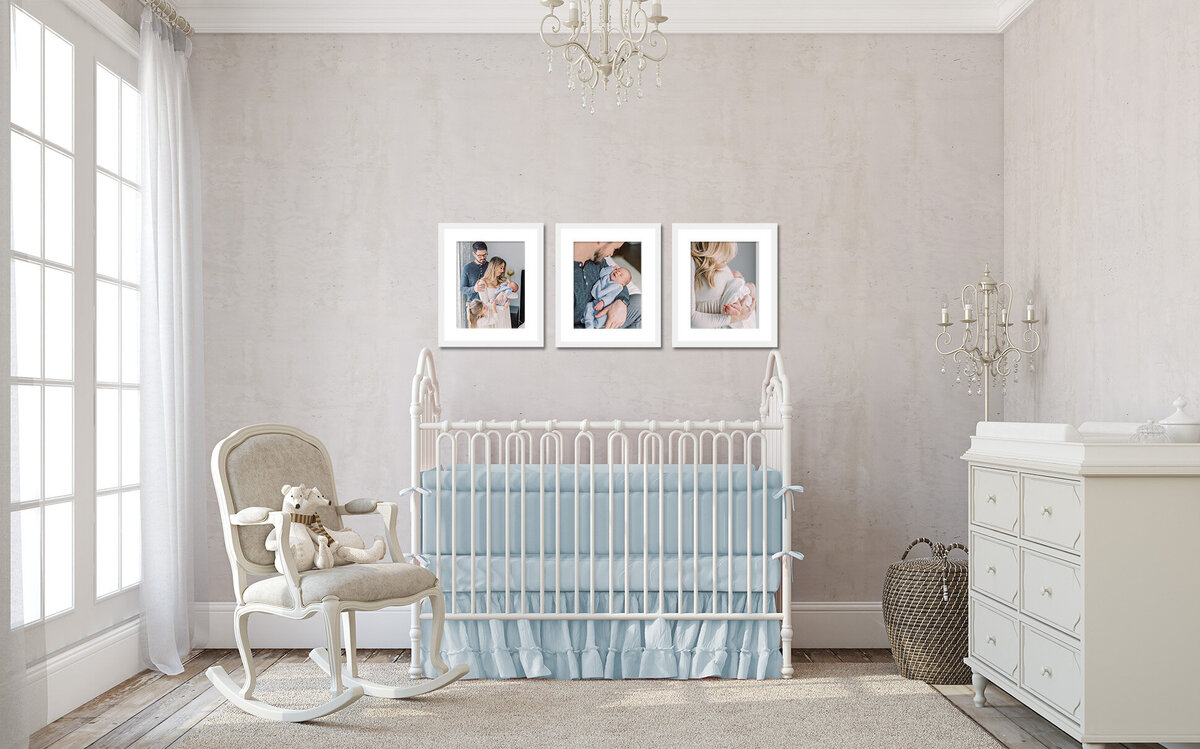 A nursery with blue bedding with three newborn portraits hanging up