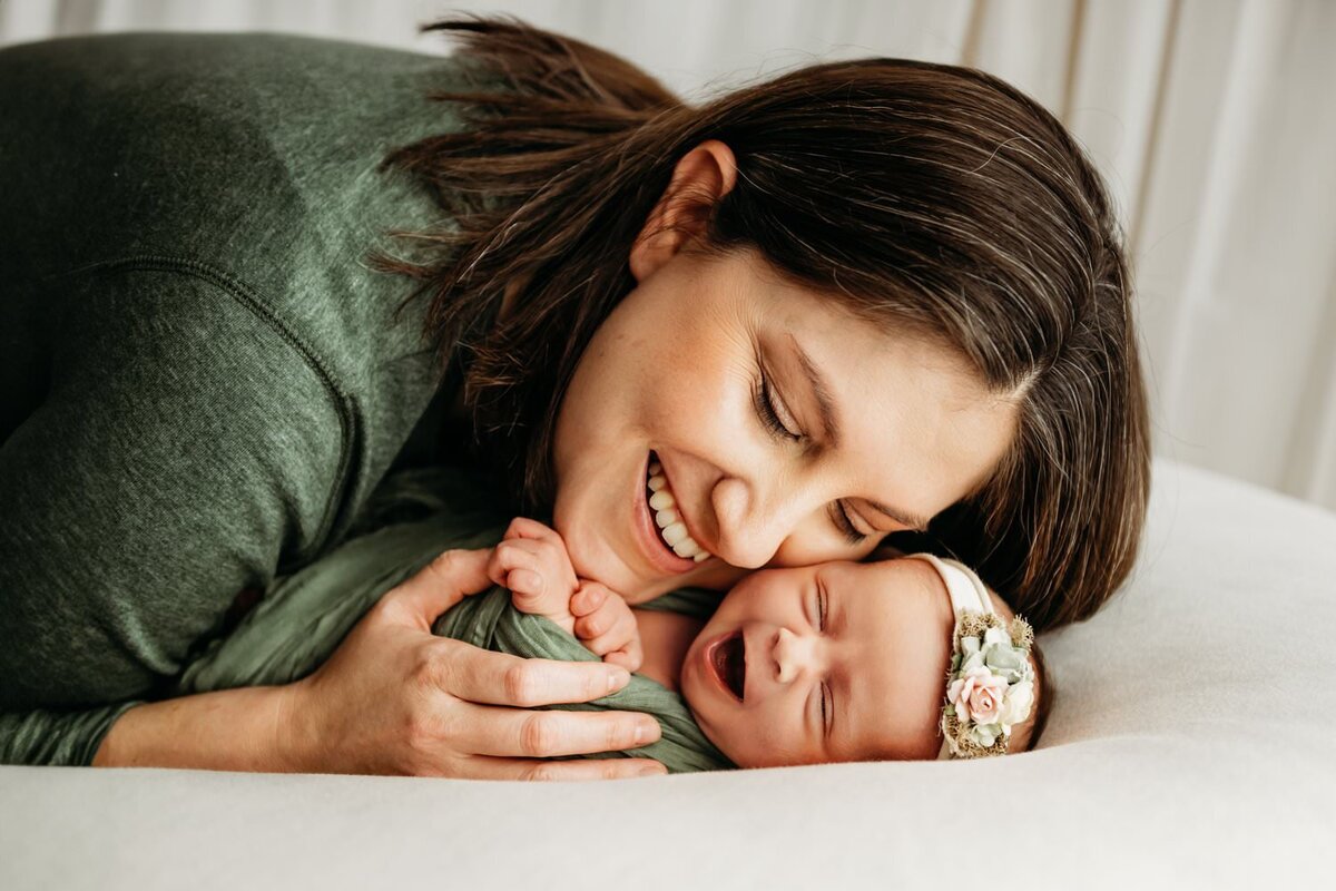 mom cuddled with newborn girl during a studio photography session in martinez