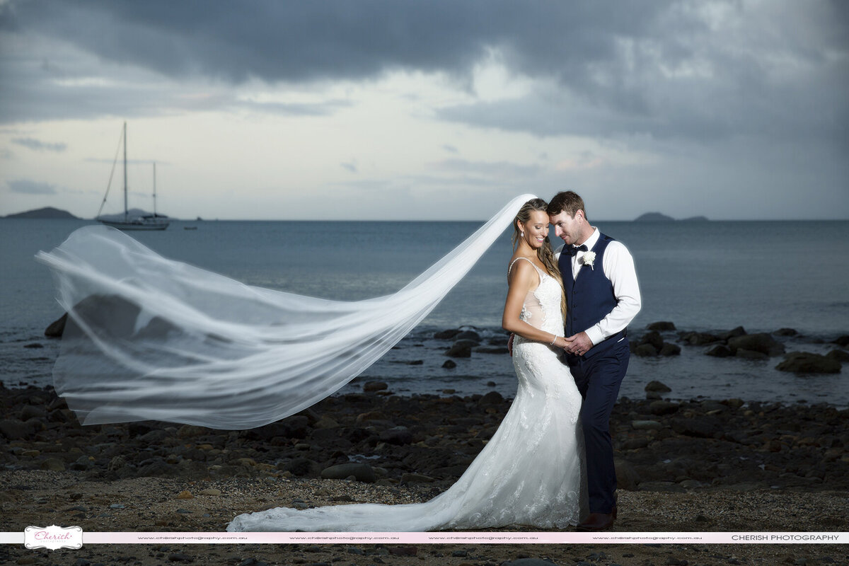 Stunning wedding photography capturing love and romance at the scenic Coral Sea beach in Airlie Beach.