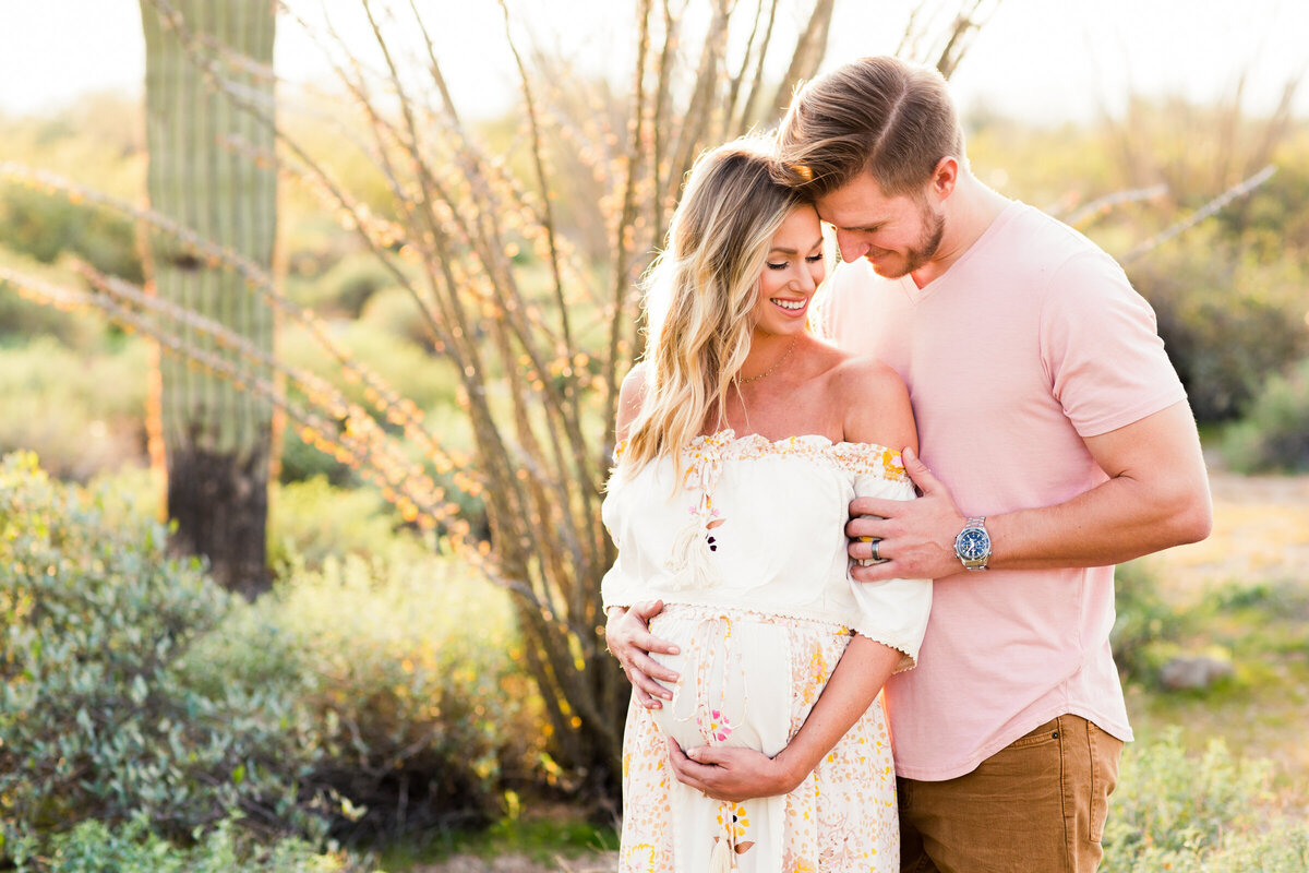 mom and dad to be embracing in the desert