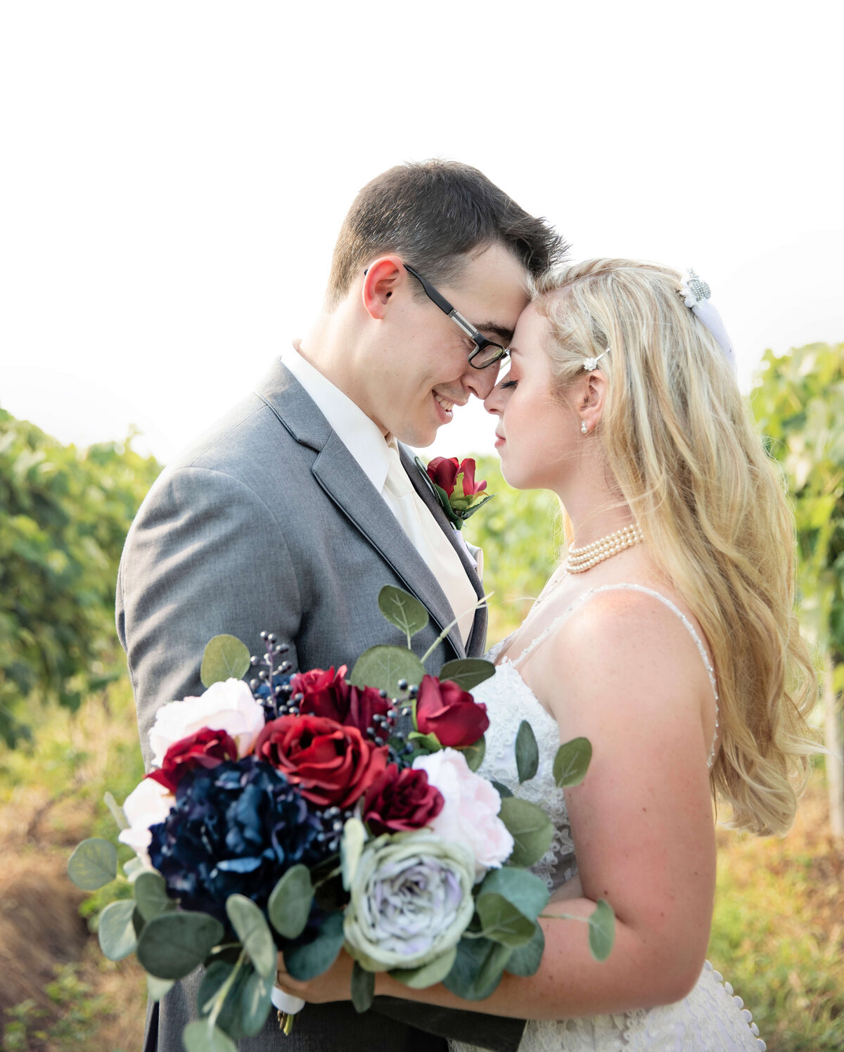 Photo of an Erie Pa bride and groom posing in a vineyard at Quincy Wine Cellars