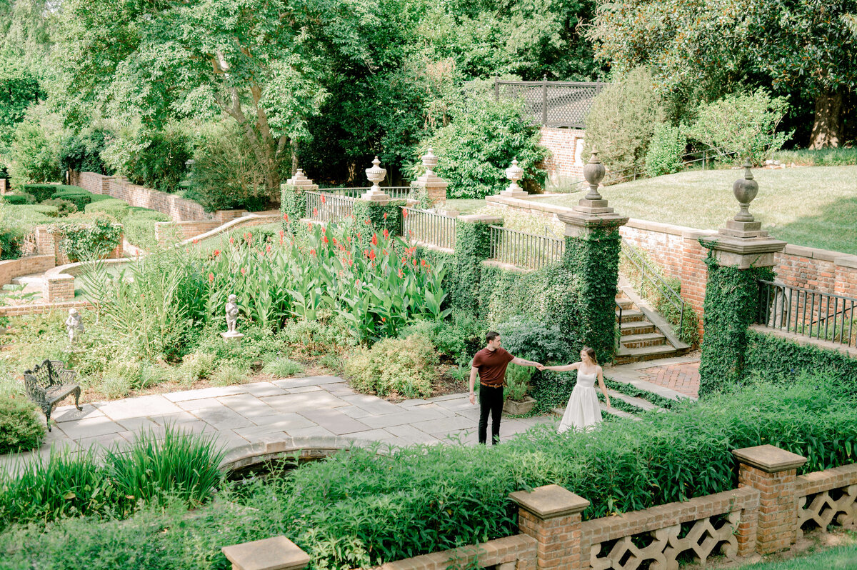 Wide shot image of a couple dancing in the gardens of the National Cathedral.