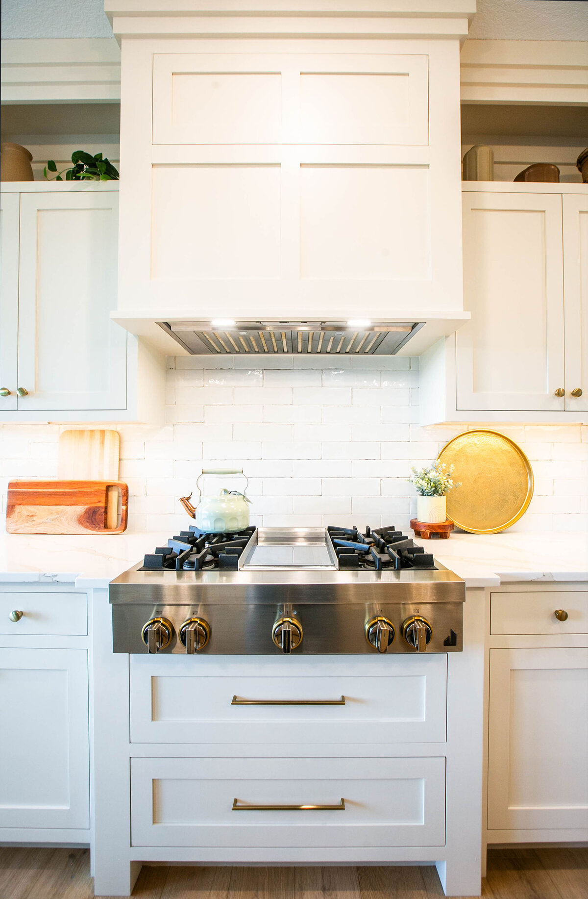 Open kitchen with white cabinets, large island, and quartz countertops in an Otsego custom home