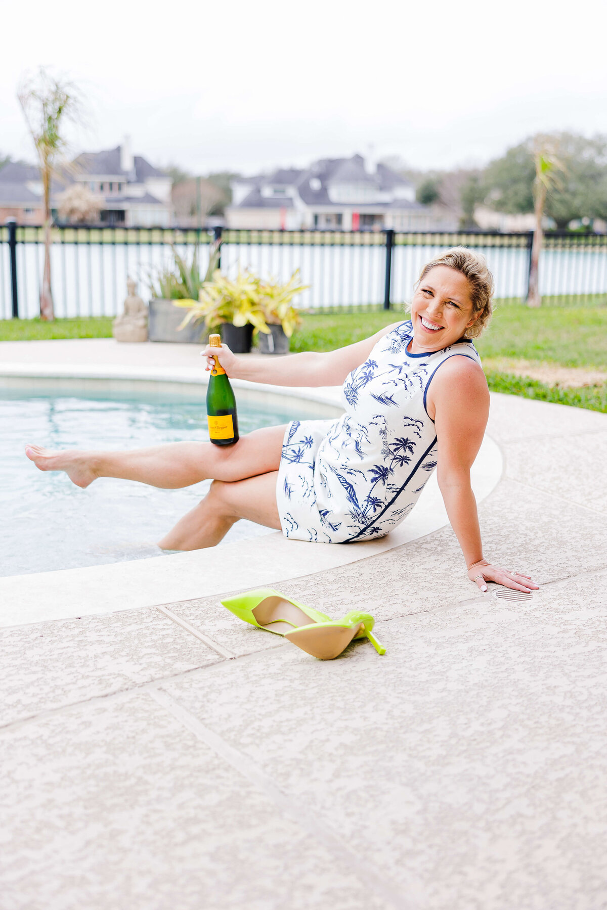Realtor with feet in pool and Champagne