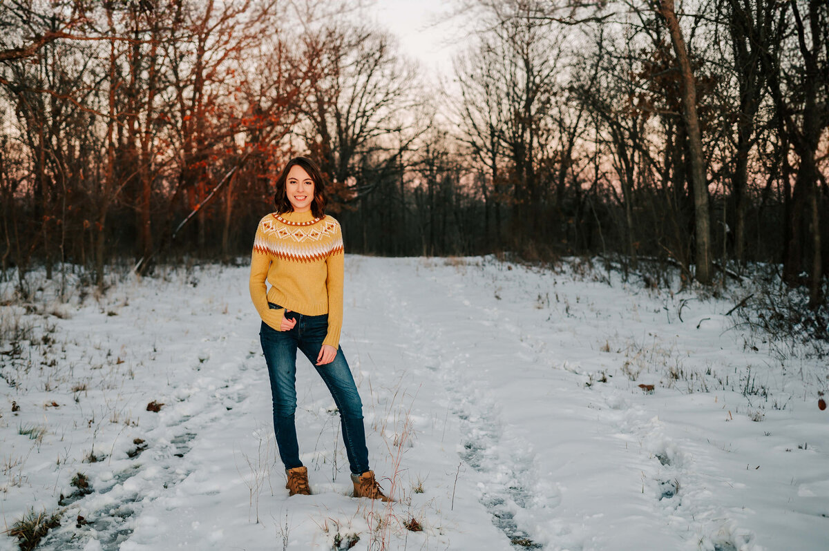 Branson MO senior photographer Jessica Kennedy of The Xo Photography captures high school senior standing in snow in the forest