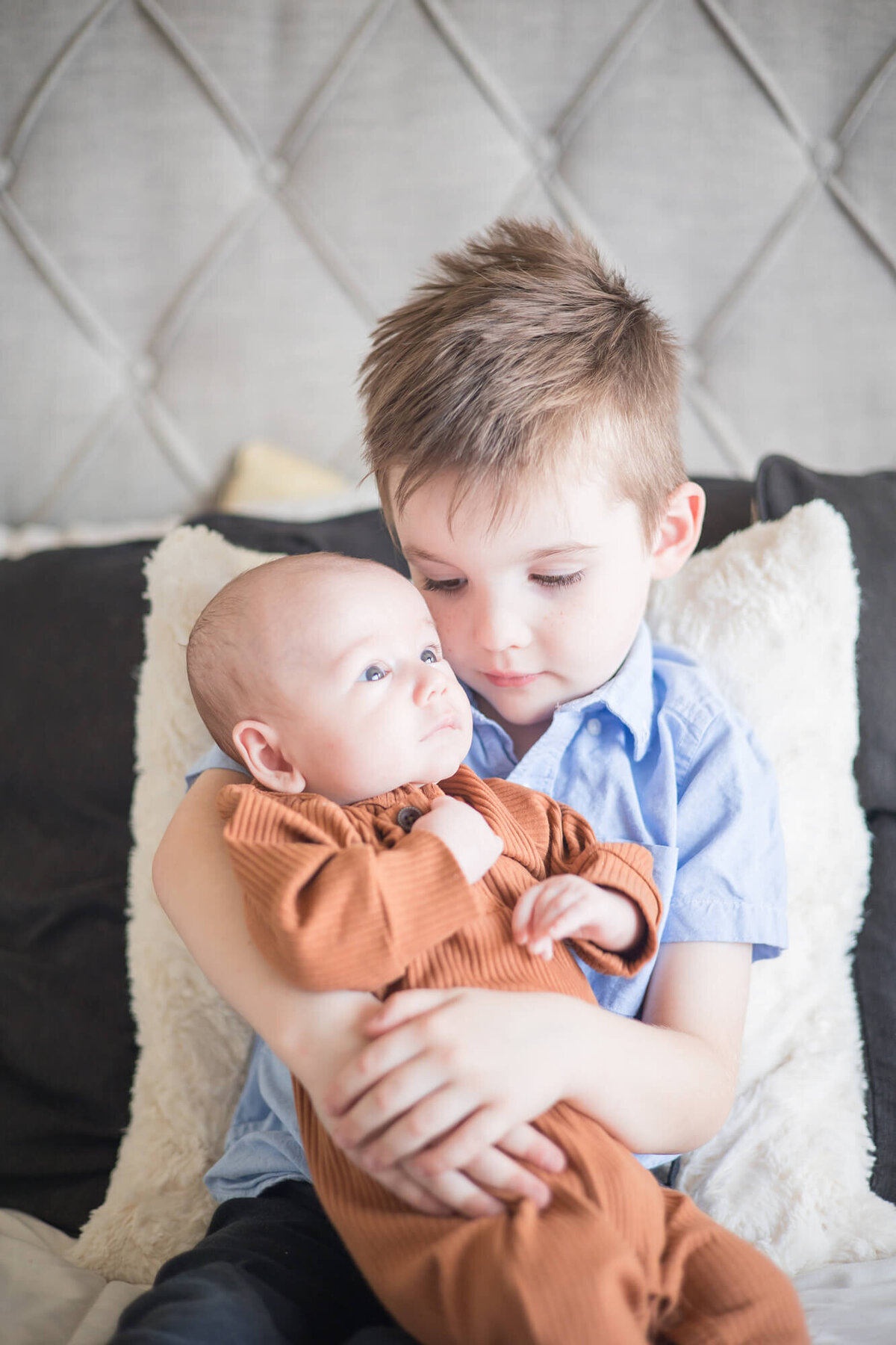 small boy lovingly holding his baby brother