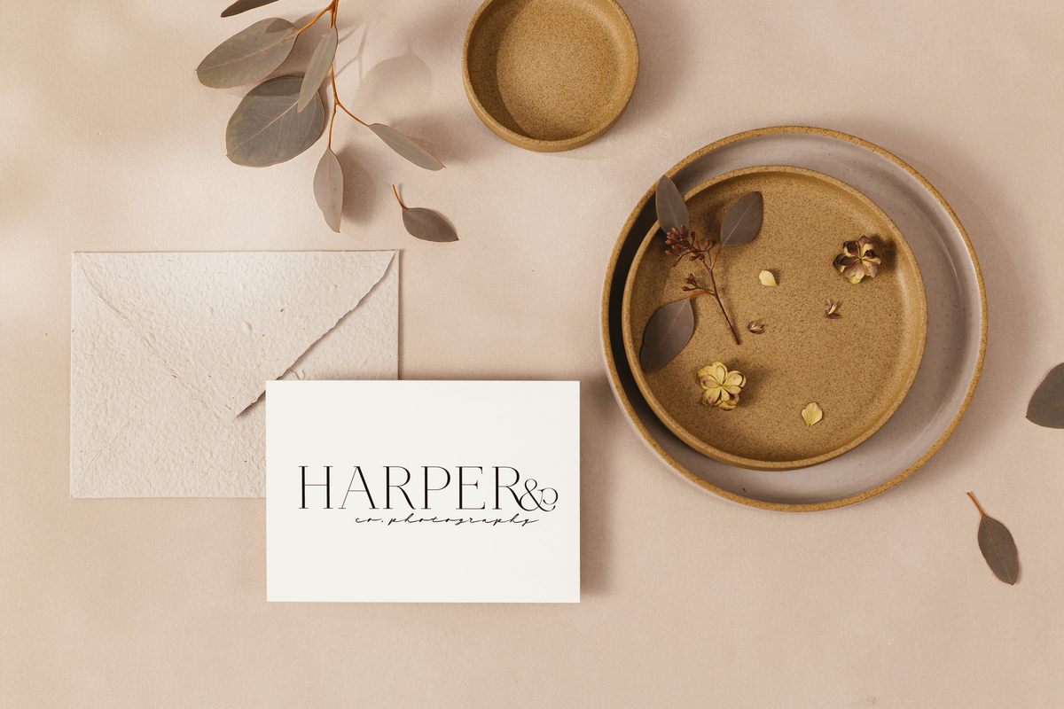 Photographer logo says Harper and Co on a desk with florals and stationary