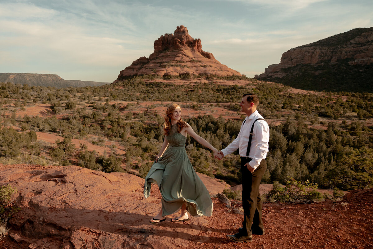 Couple standing against red rock backdrop during Sedona engagement session