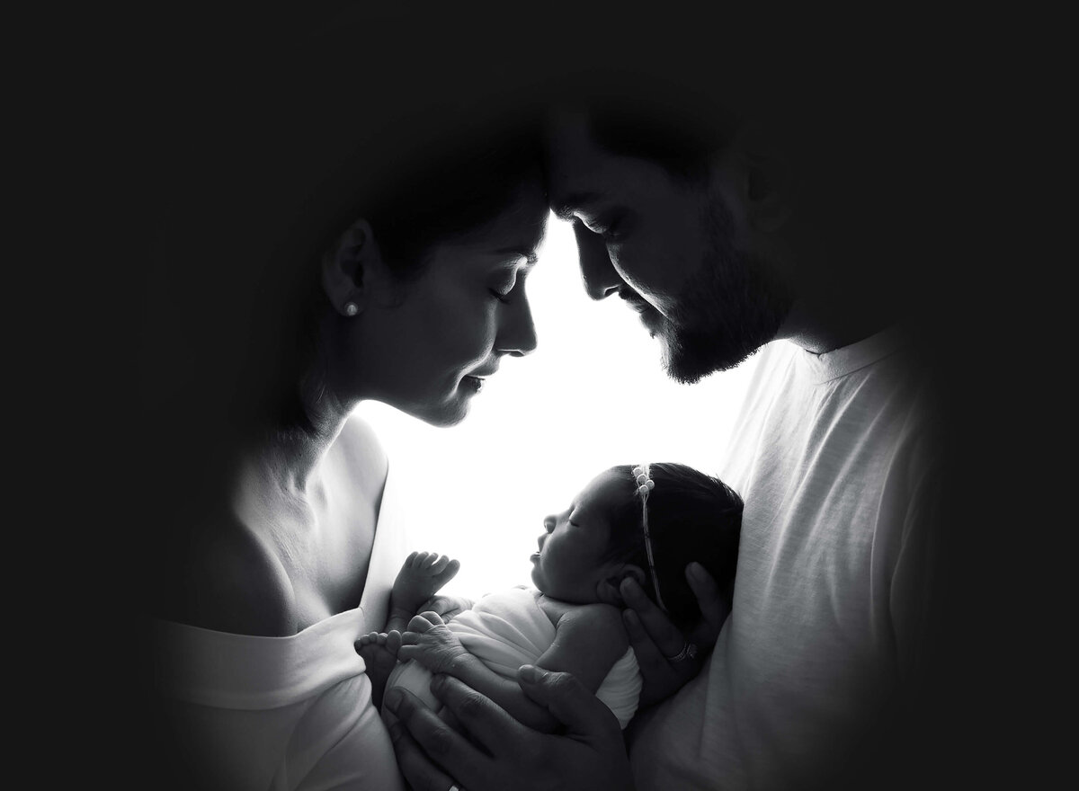 Timeless black-and-white newborn portraits of first-time parents looking at their baby with love, captured in a Manhattan newborn photography session.