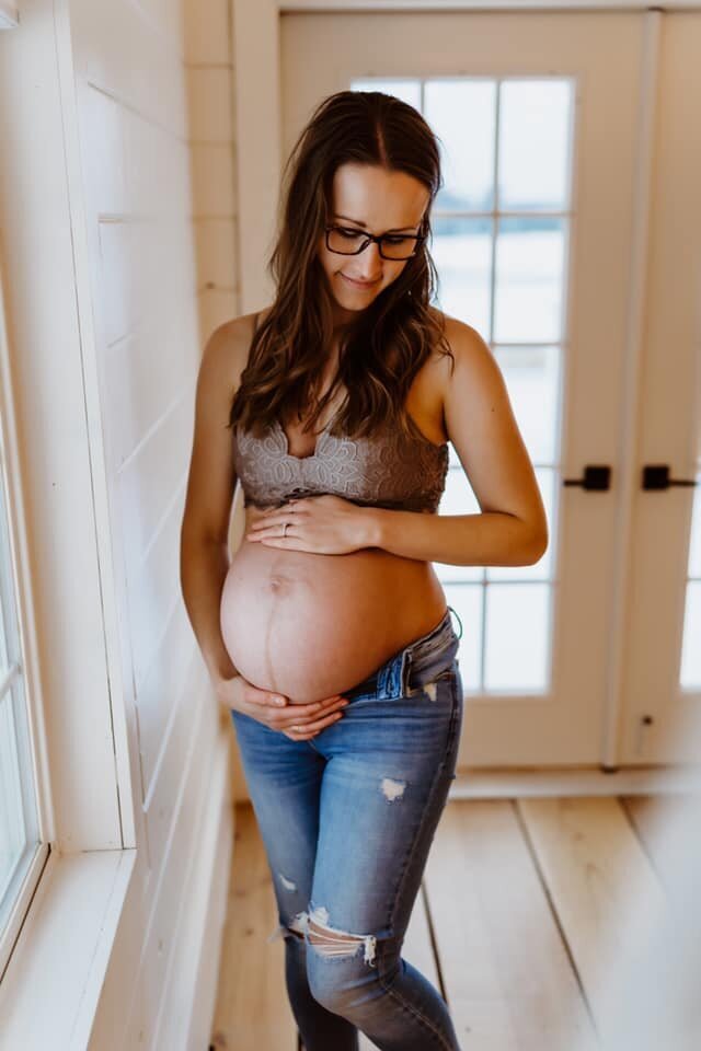woman posing in front of window pregnant
