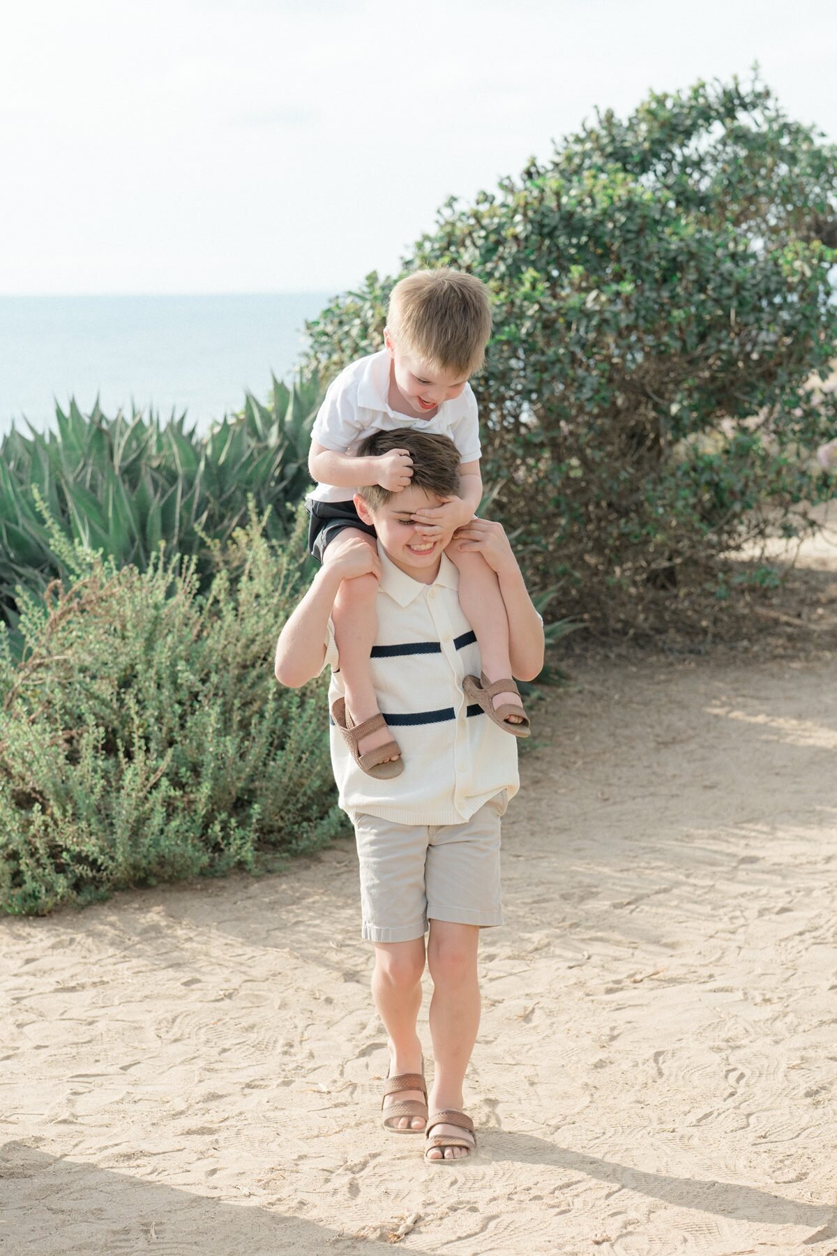 Siblings laughing at San Diego family photoshoot in Del Mar