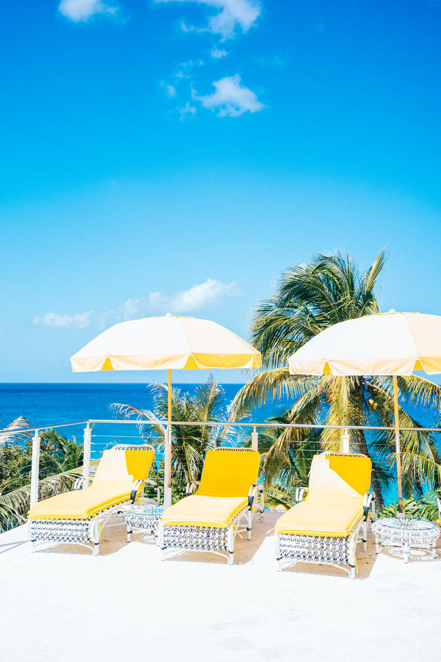 pool deck at malliouhana yellow umbrellas