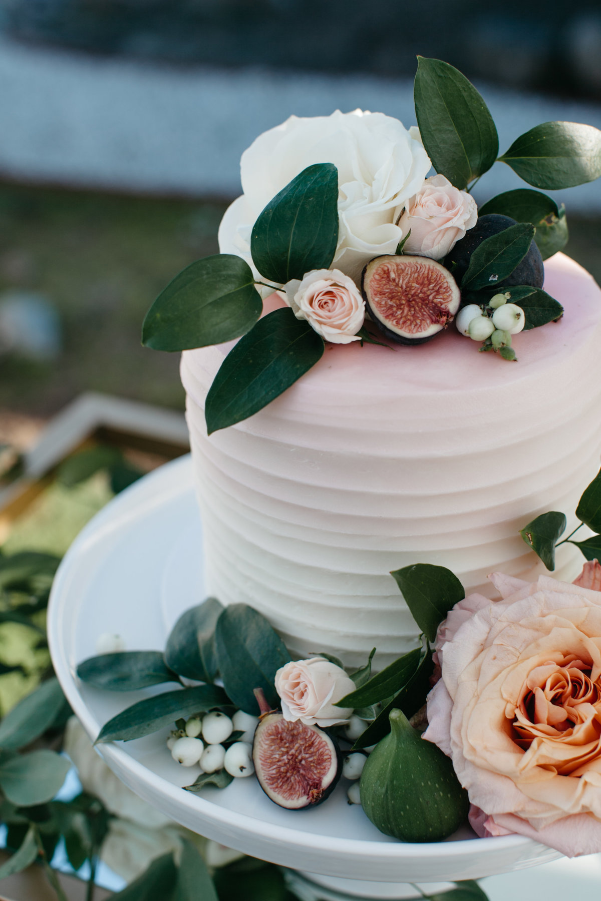 Romantic garden wedding cake decorated with blush shimmer roses and figs.