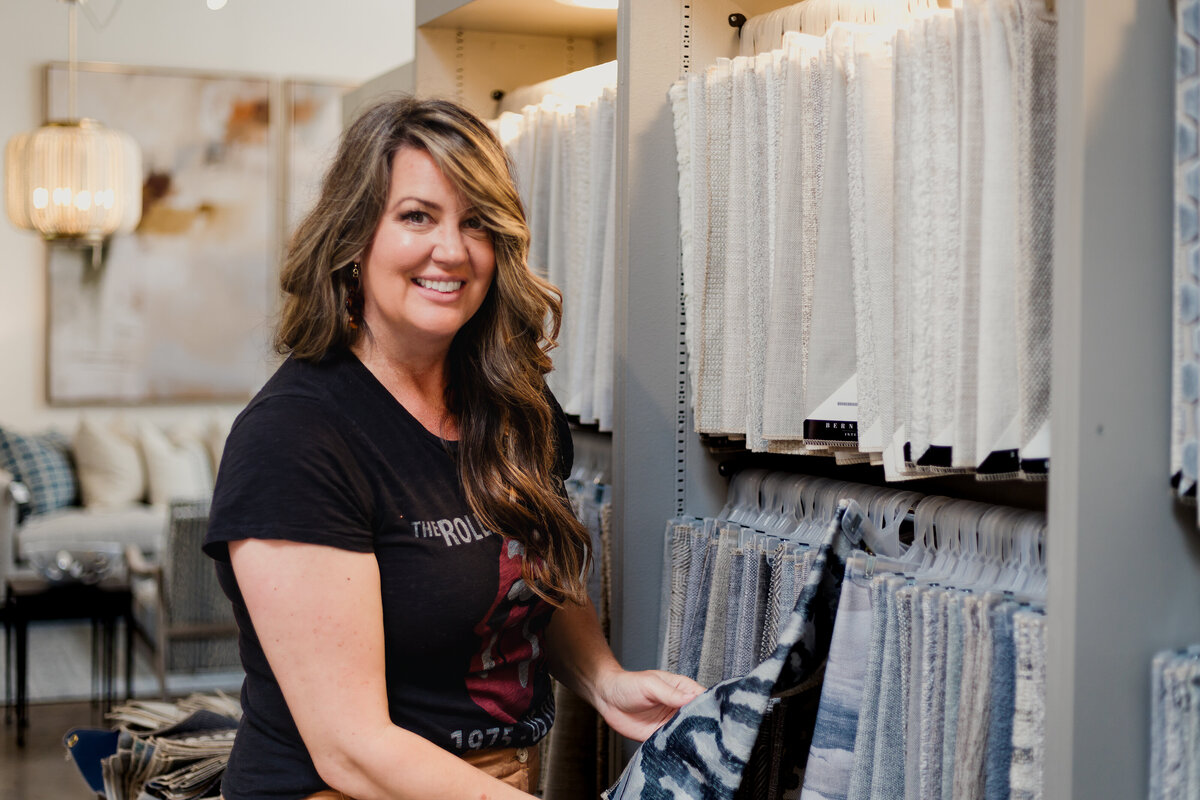 Interior Designer in showroom in front of wall of textiles