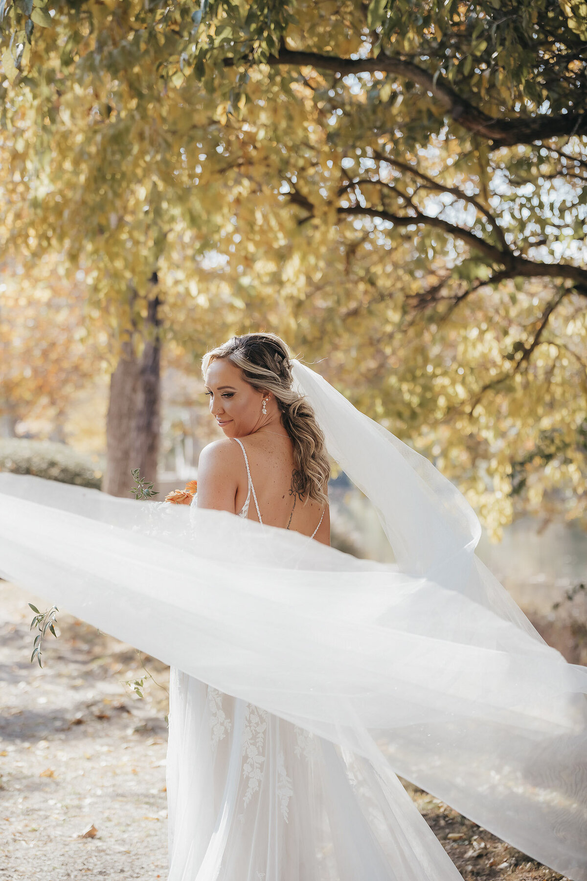 bride swirling her veil outside