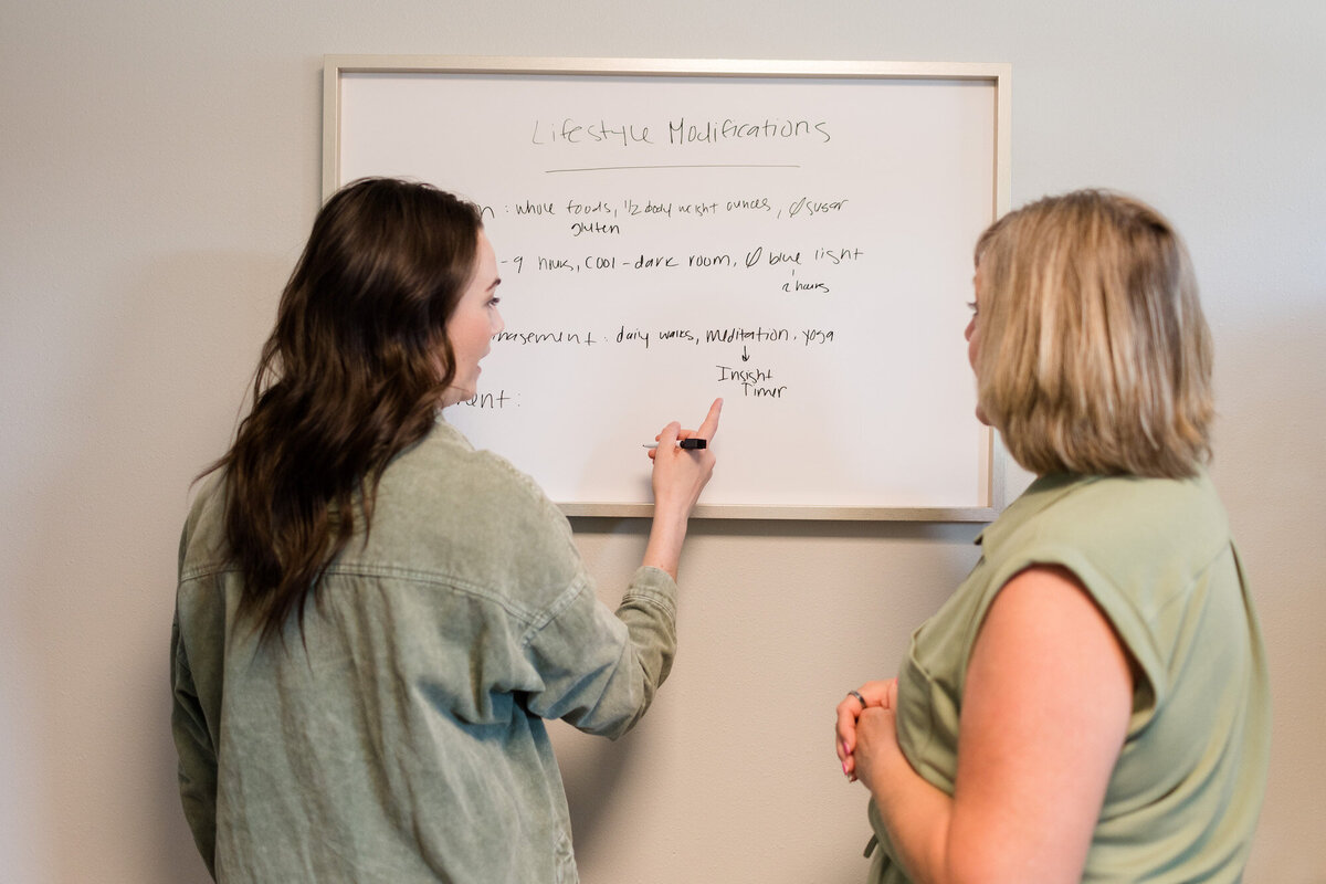 Dr. Brea teaching patient on a white baord