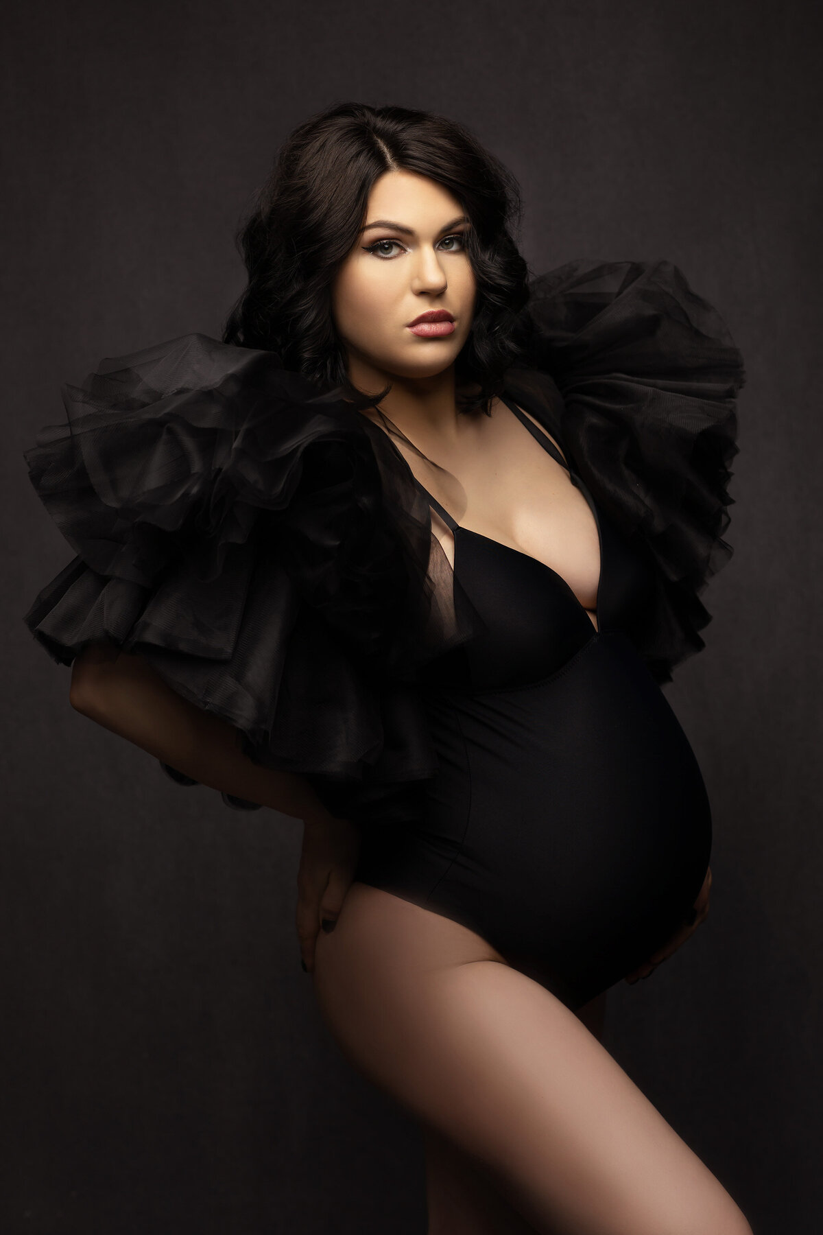 Dallas maternity photography featuring woman in black bodysuit with dramatic tulle shoulders. Captured by Lindsay Walden Photography.