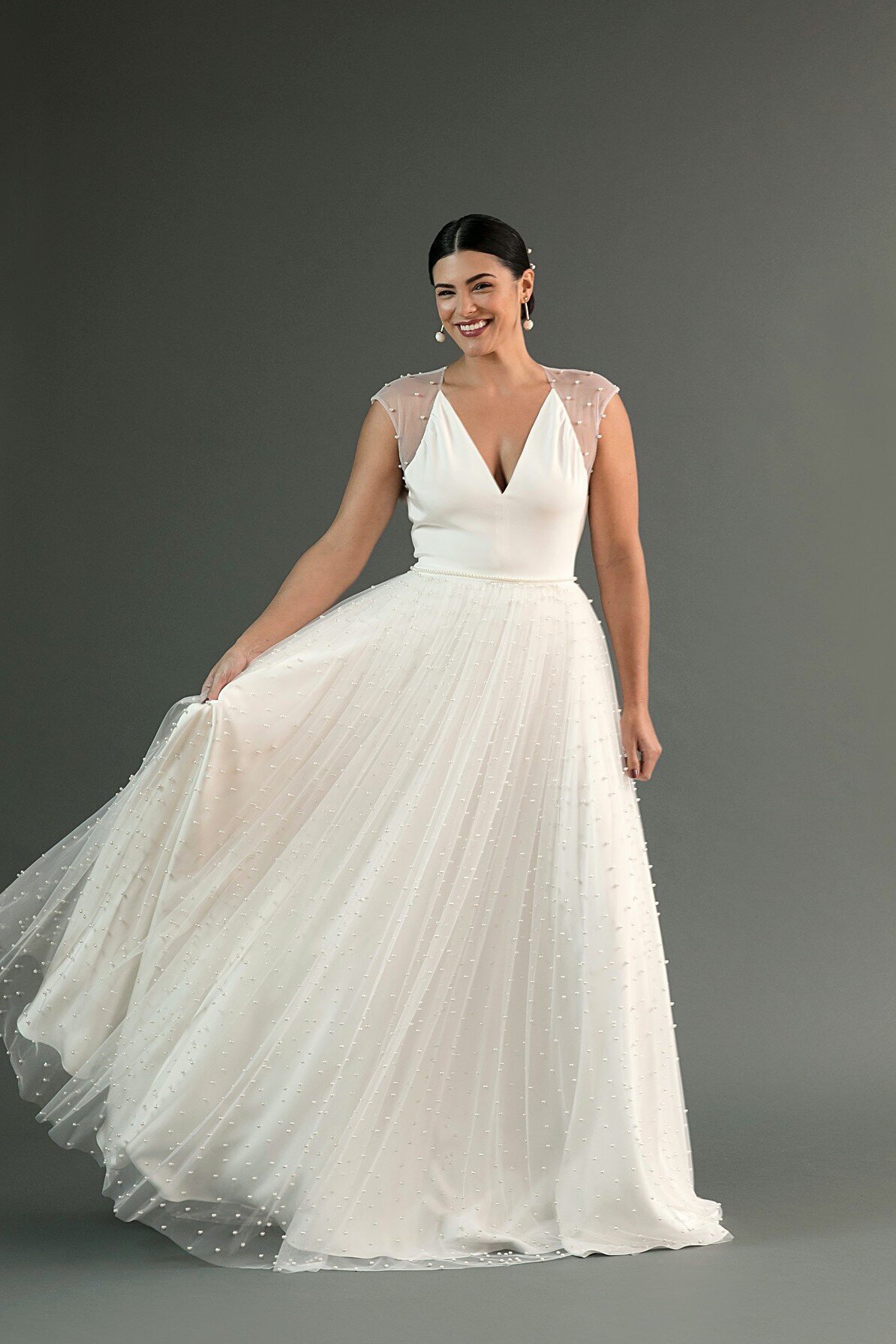 The Chika bridal style by indie bridal designer Edith Elan is an a-line crepe and pearl wedding dress.