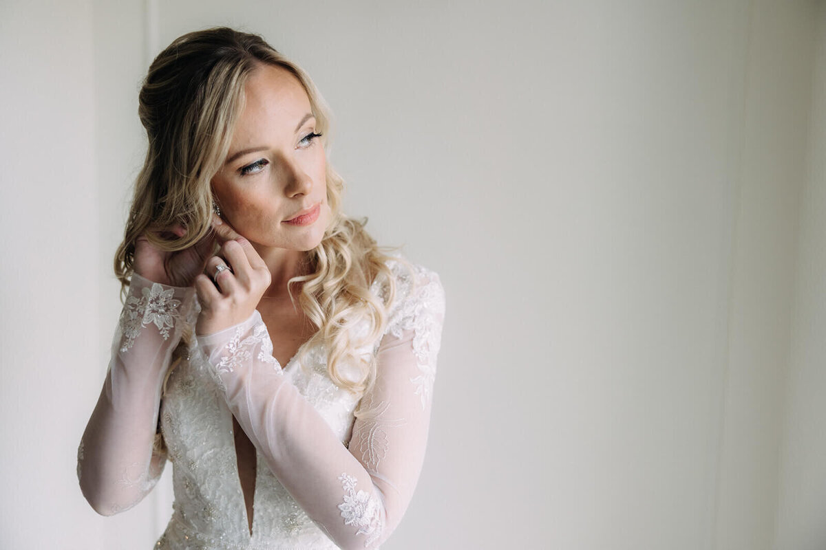 Bride putting earrings in
