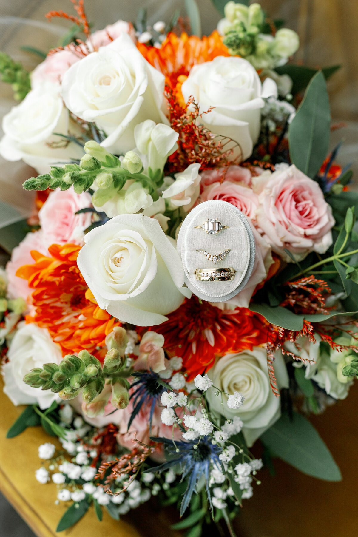 Vibrant detail photo of a bride and groom's bouquet and wedding rings