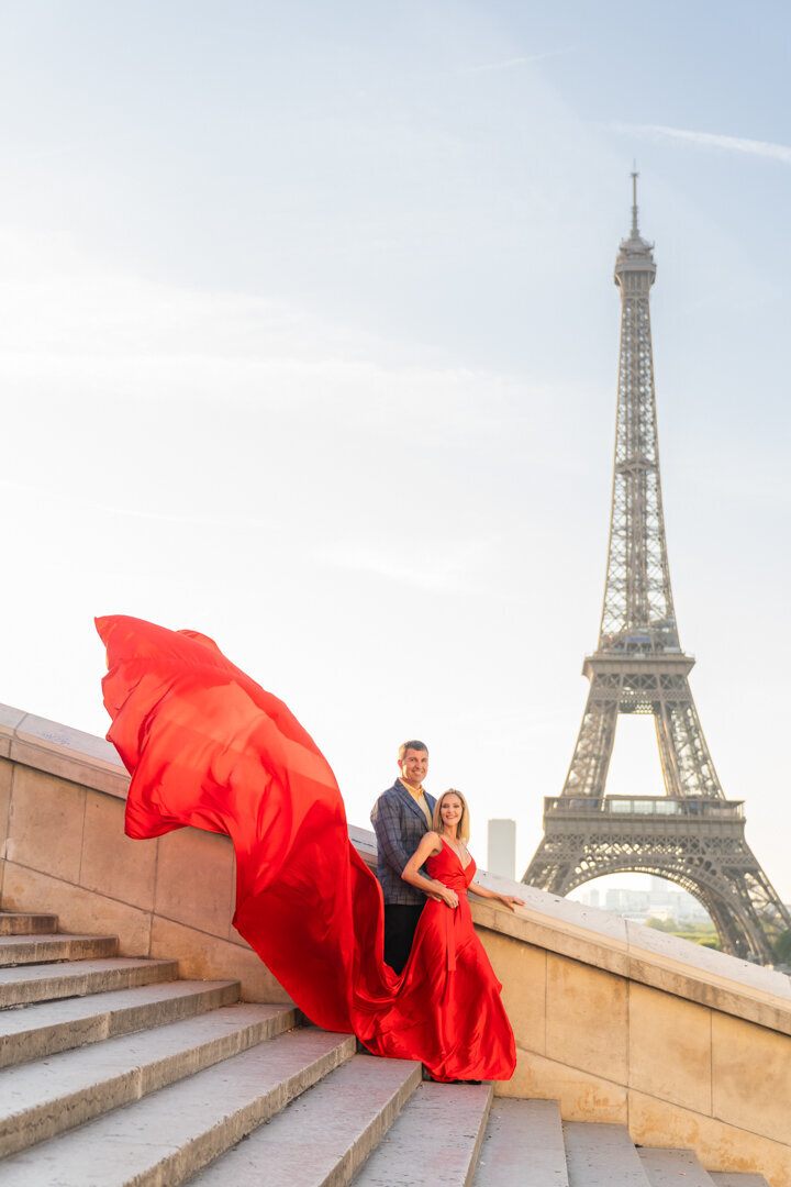 Paris couple photo session at Eiffel Tower, woman in flowing red flying dress, professional photography experience