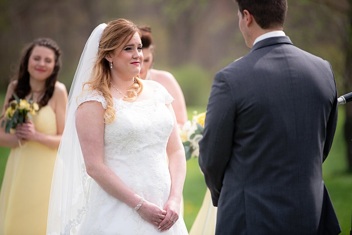 Bride looks at Groom during outdoor wedding ceremony at White Barn in Prospect, PA
