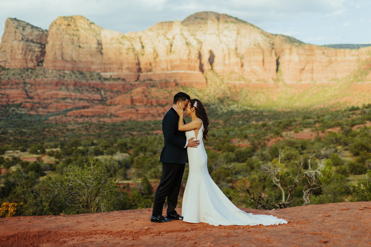 man and woman stand together with sedona landscape around them