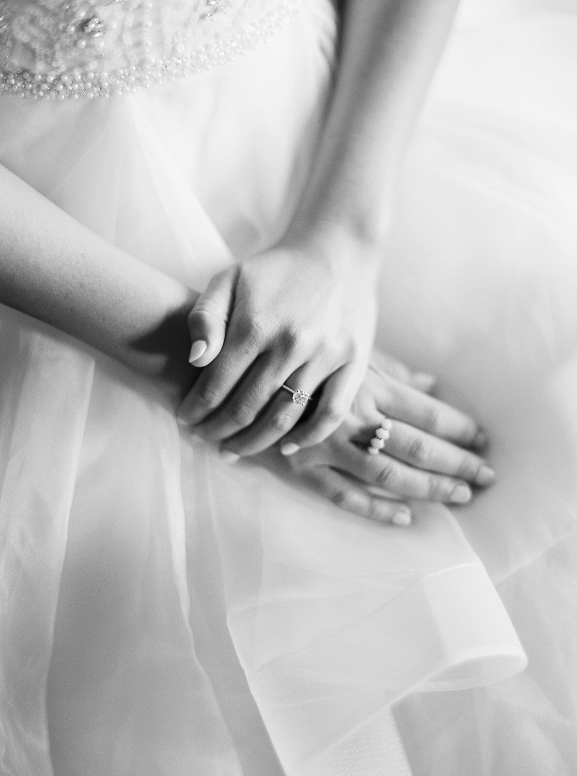 close up of bride's hands on her dress