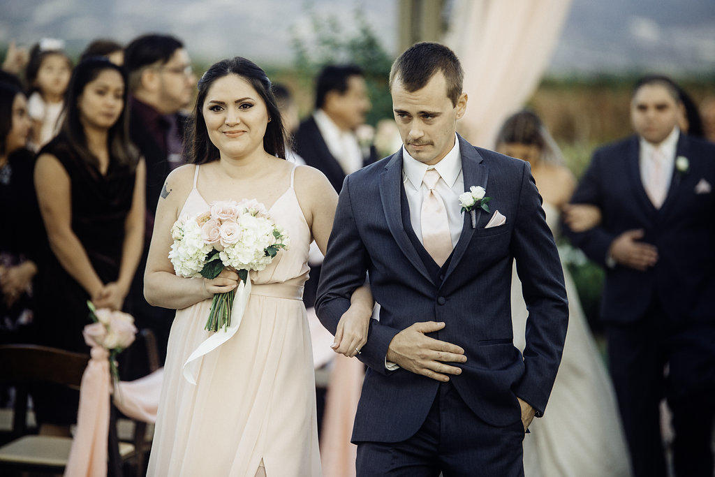 Wedding Photograph Of Bridesmaid And Groomsman With His Hand in Pocket While Walking Los Angeles