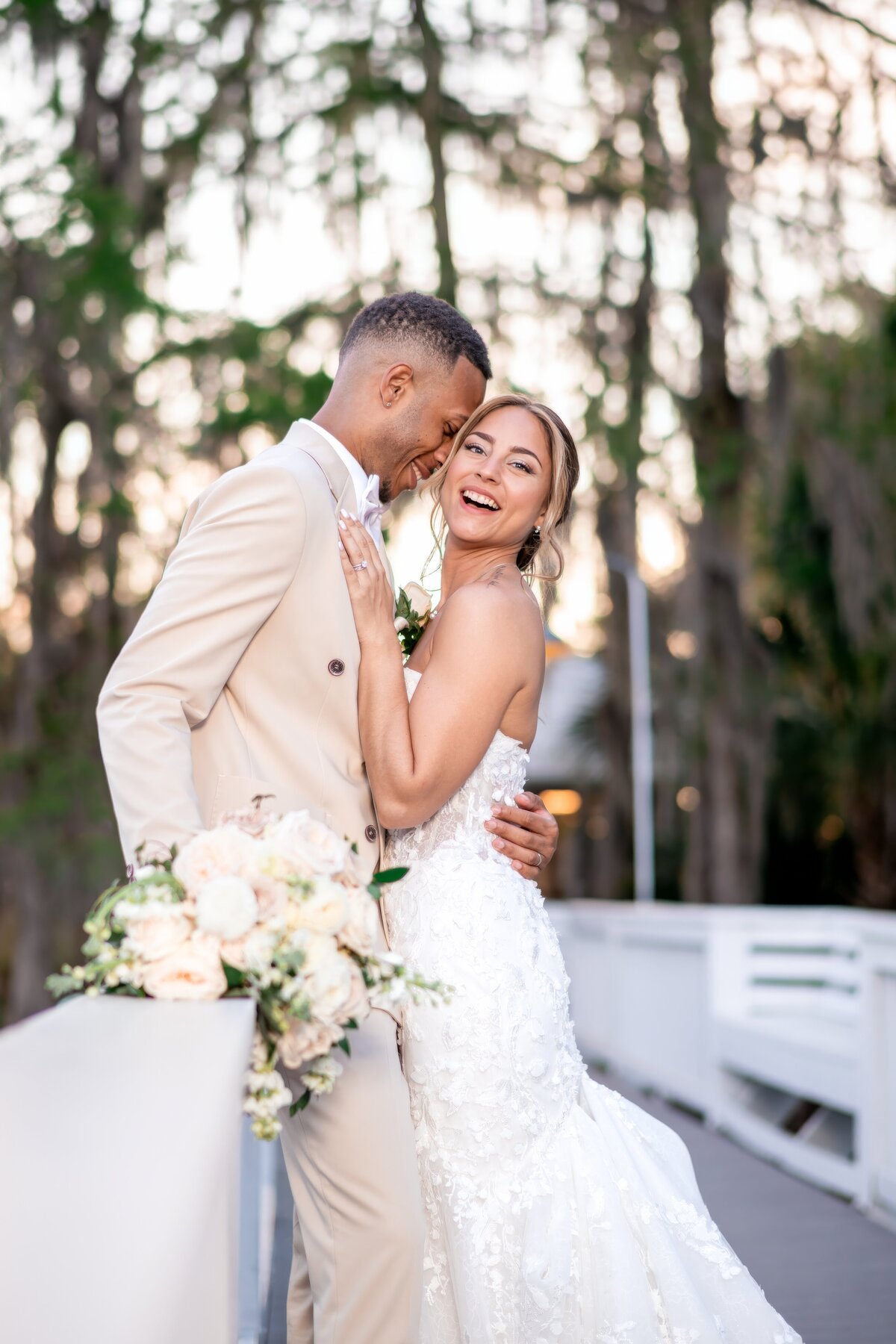 couple on laughing in wedding outfits