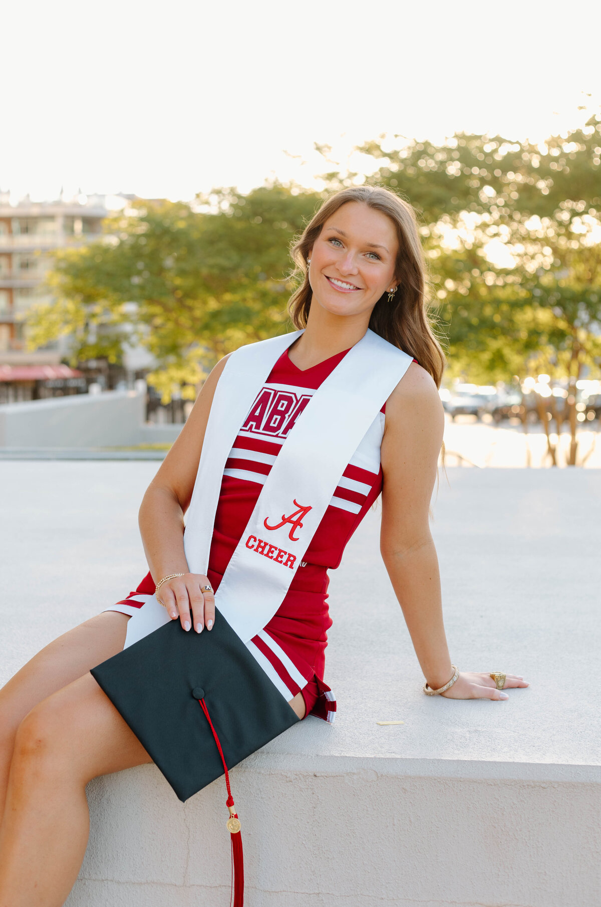 UA cheerleader at Bryant denny stadium with graduation cap