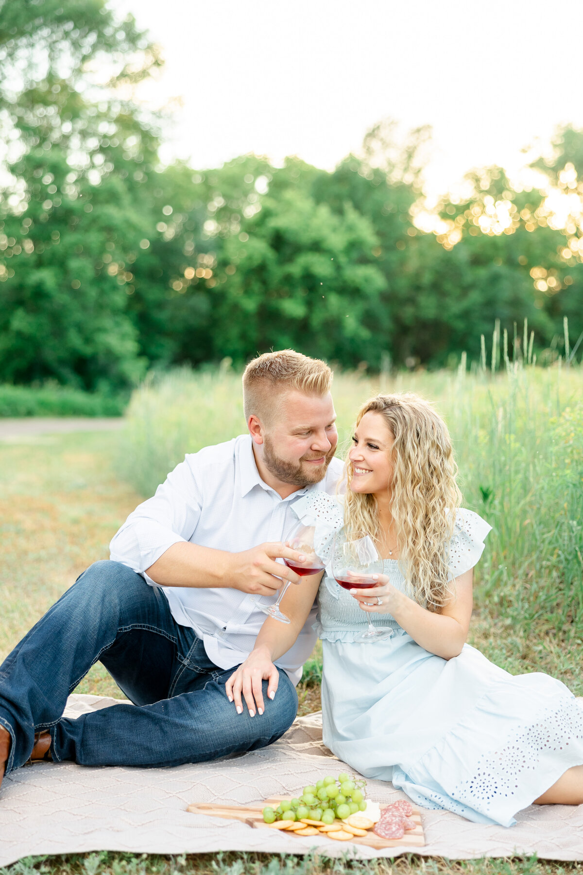 couple sitting on blanket in a field by wedding photographers in orlando fl