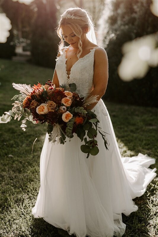 Bride holding large burgundy and blush  bouquet with wild flowers in Purcellville, VA